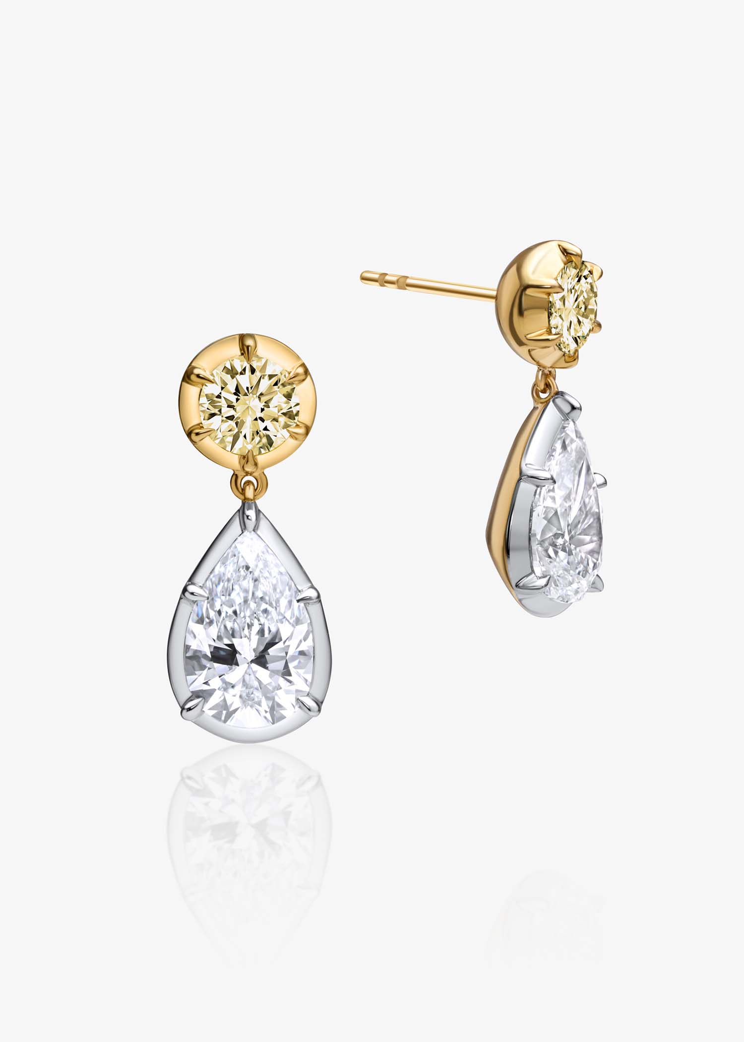 Gold diamond pear drop earrings displayed on white background with reflection.