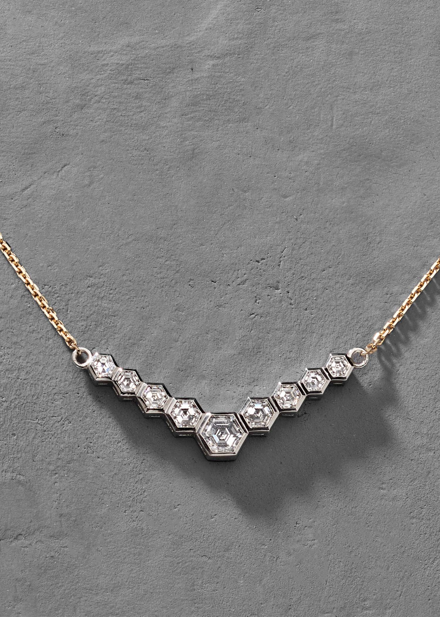 Gold hexagon diamond necklace shown on white background for product display.
