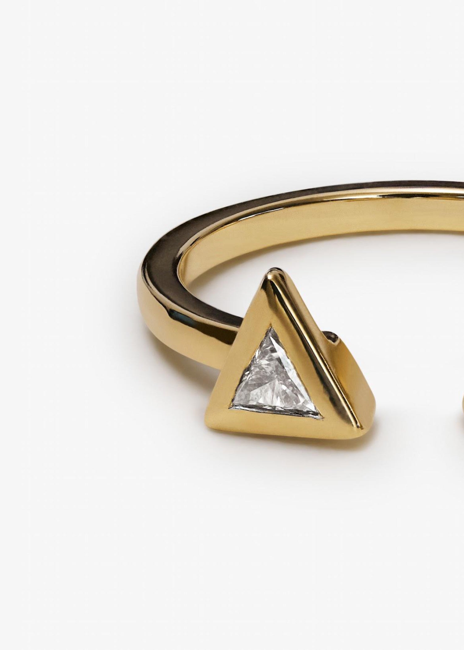 Close-up of yellow gold ring featuring twin triangular diamonds with modern open design.