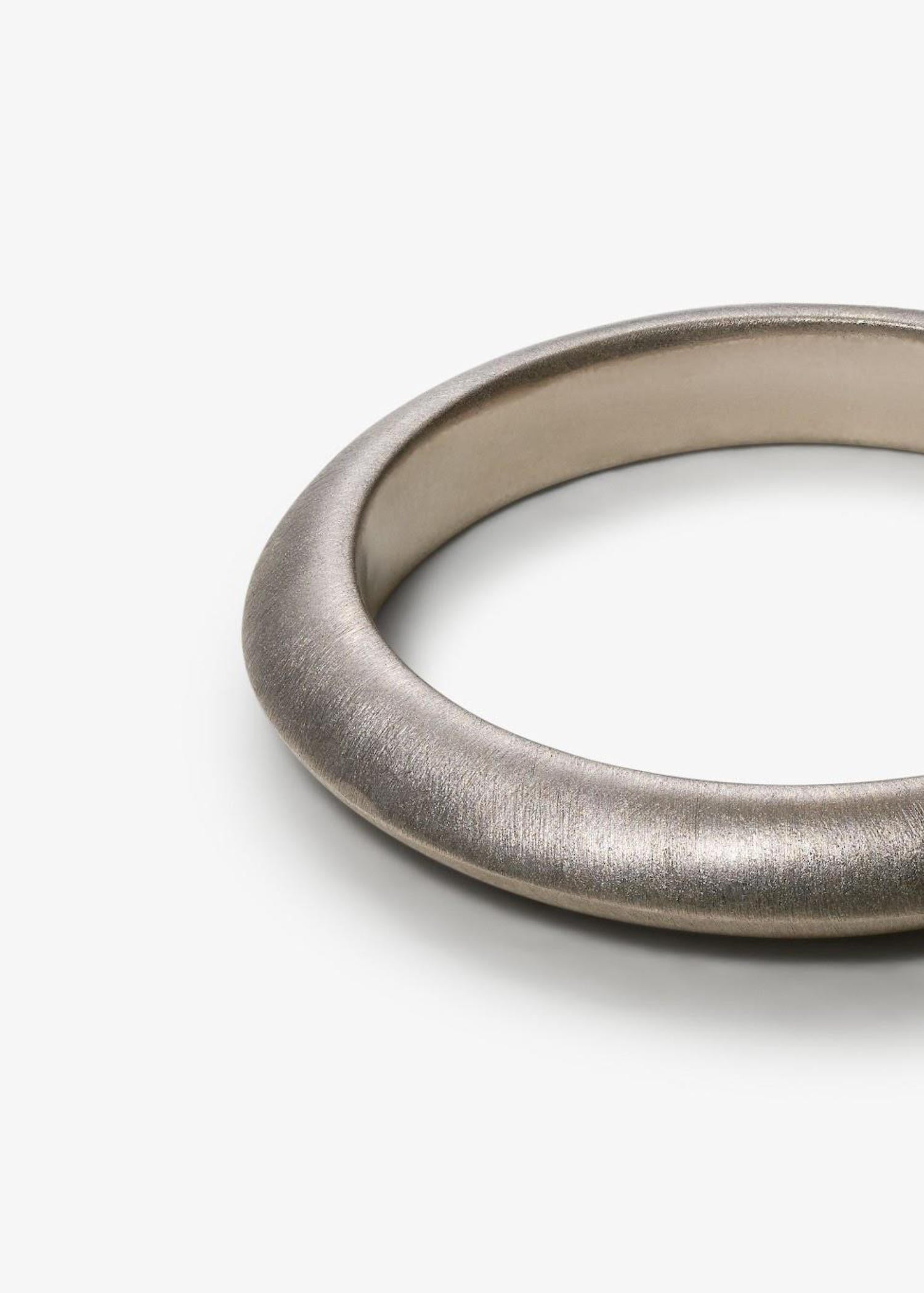 Person wearing a brown pinstripe garment with a close-up of hands and a ring.