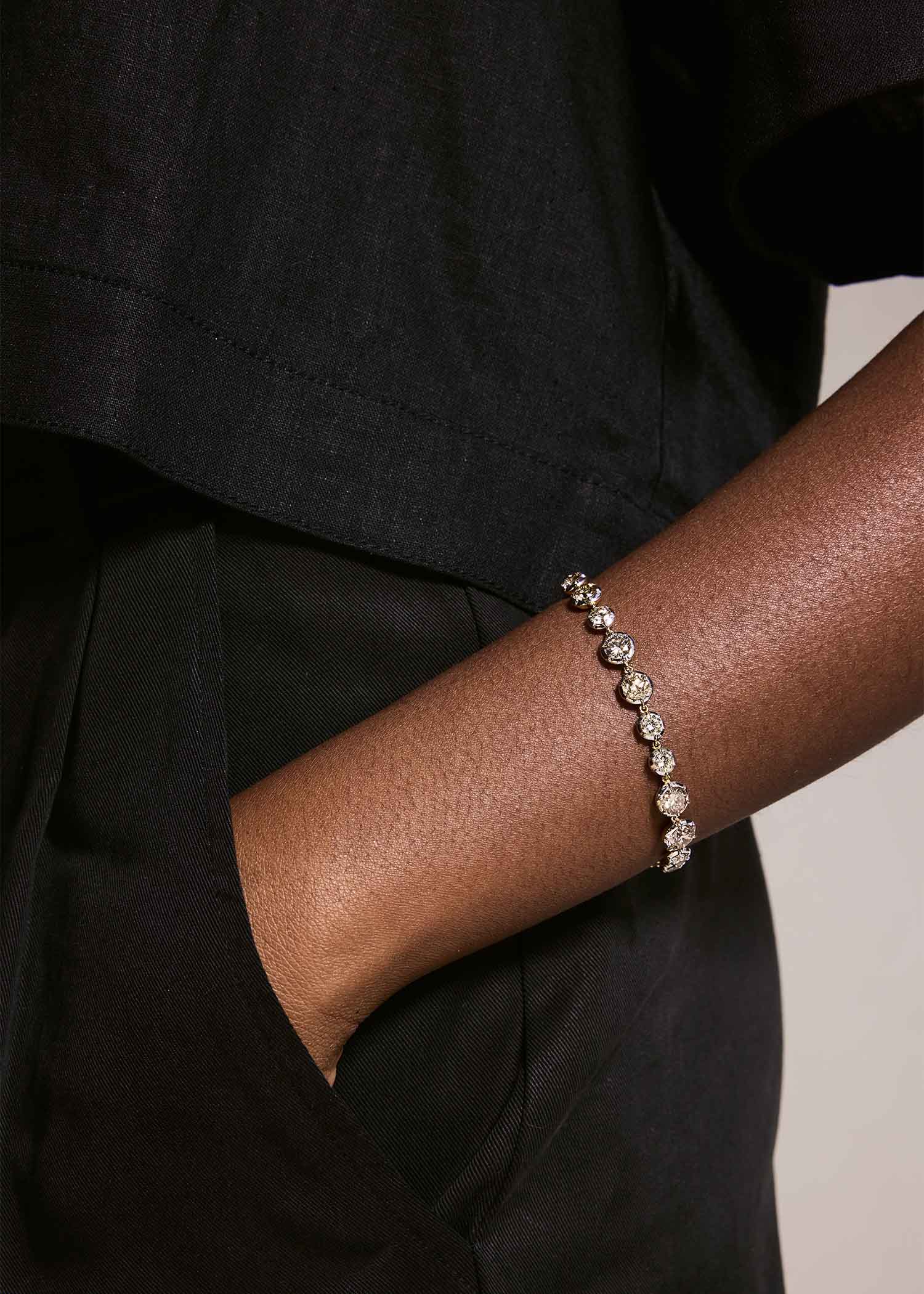 Person wearing a bracelet on a plain background.