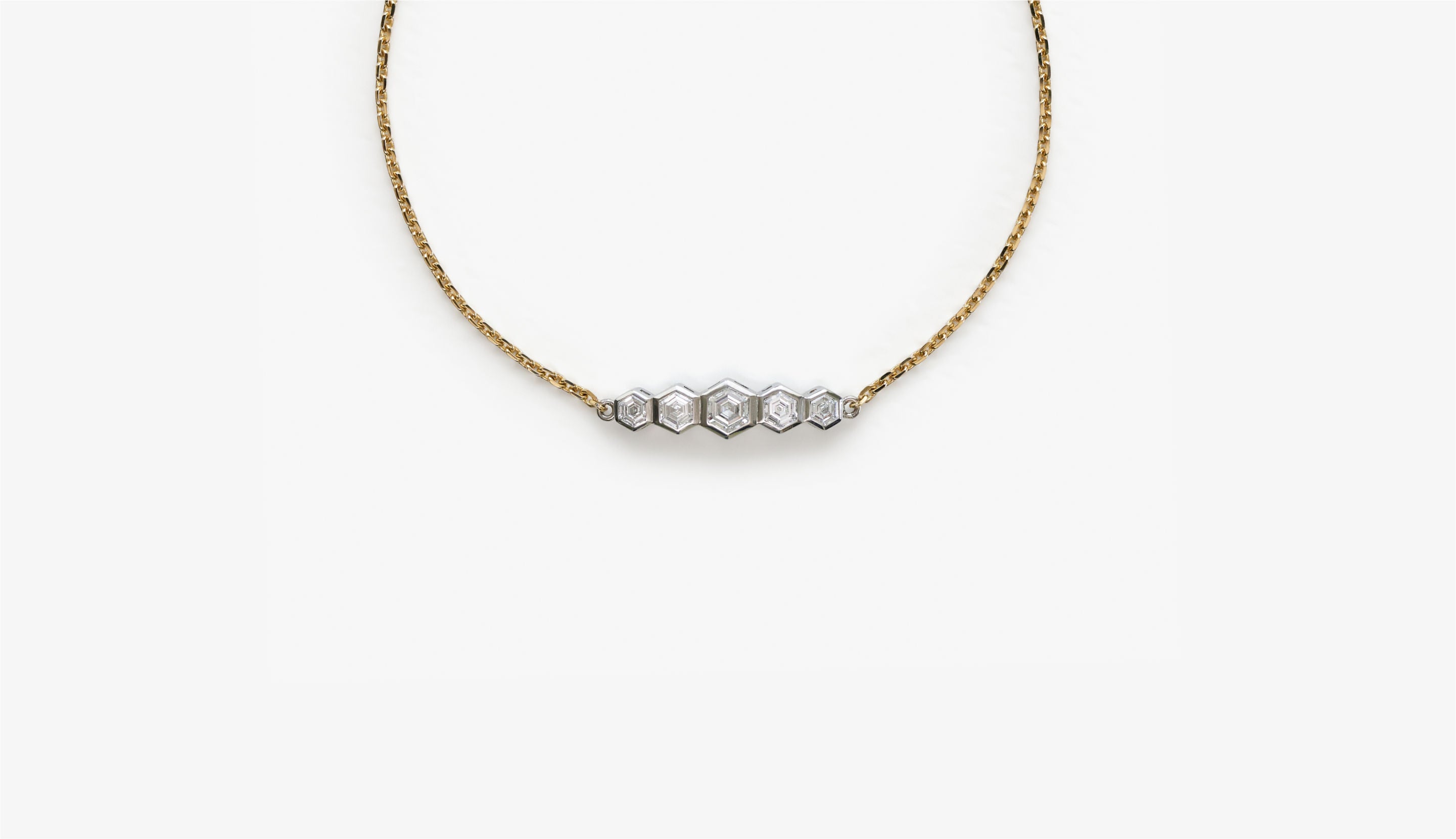 Blonde woman with slicked-back hair wearing a black strapless top and a choker necklace with a large light blue gemstone.