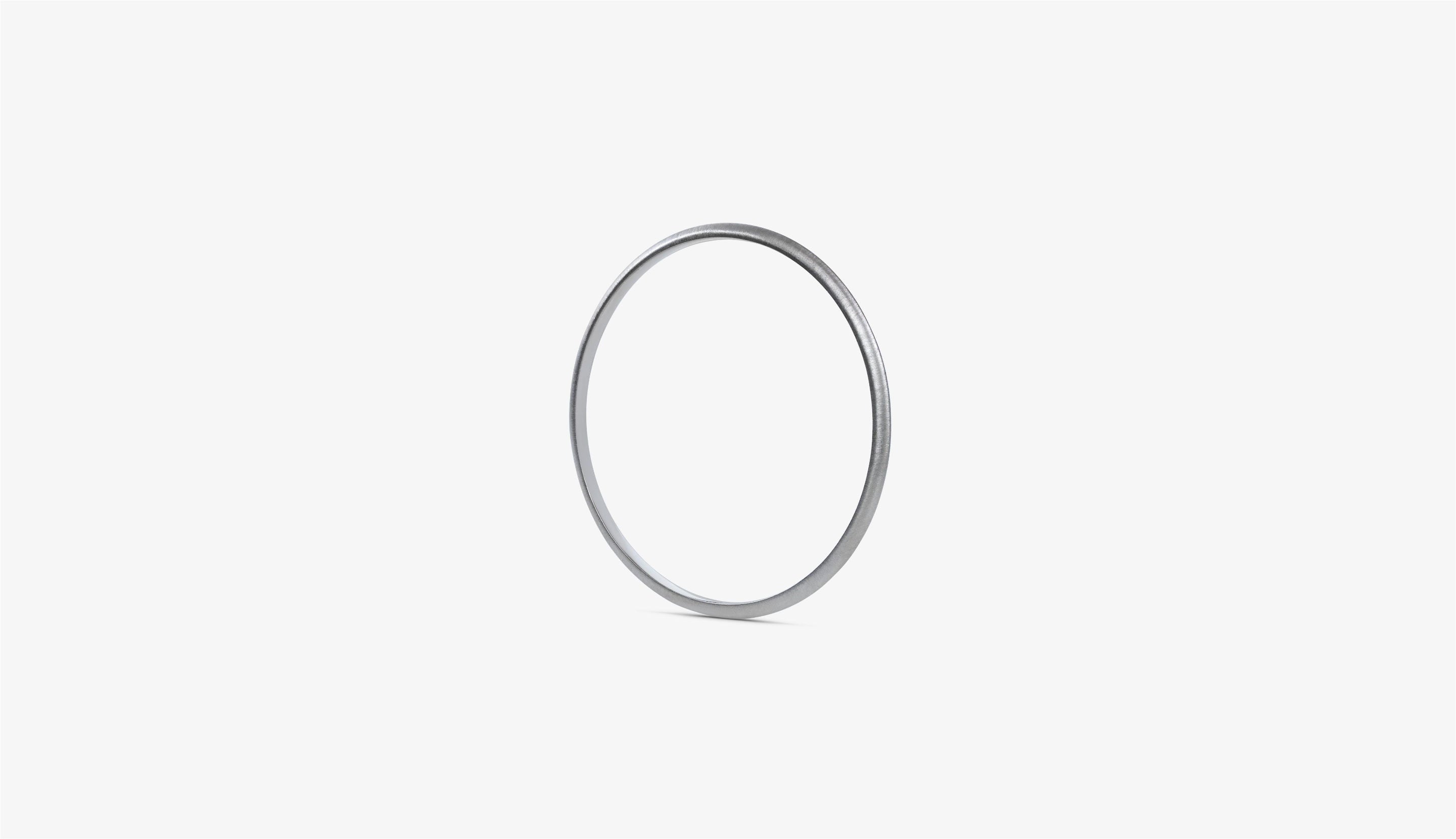 Blonde woman with slicked-back hair wearing a black strapless top and a choker necklace with a large light blue gemstone.