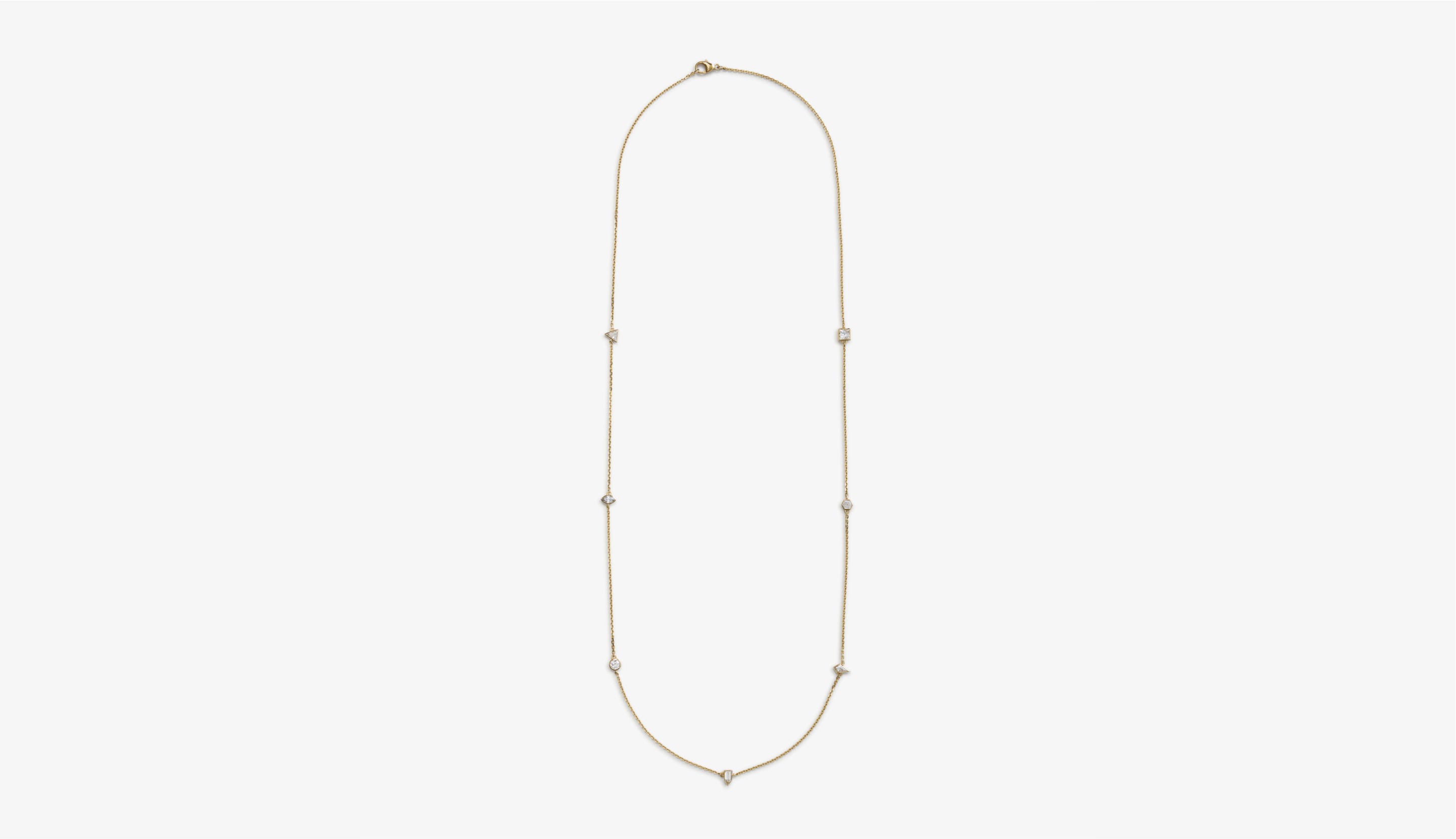 Blonde woman with slicked-back hair wearing a black strapless top and a choker necklace with a large light blue gemstone.