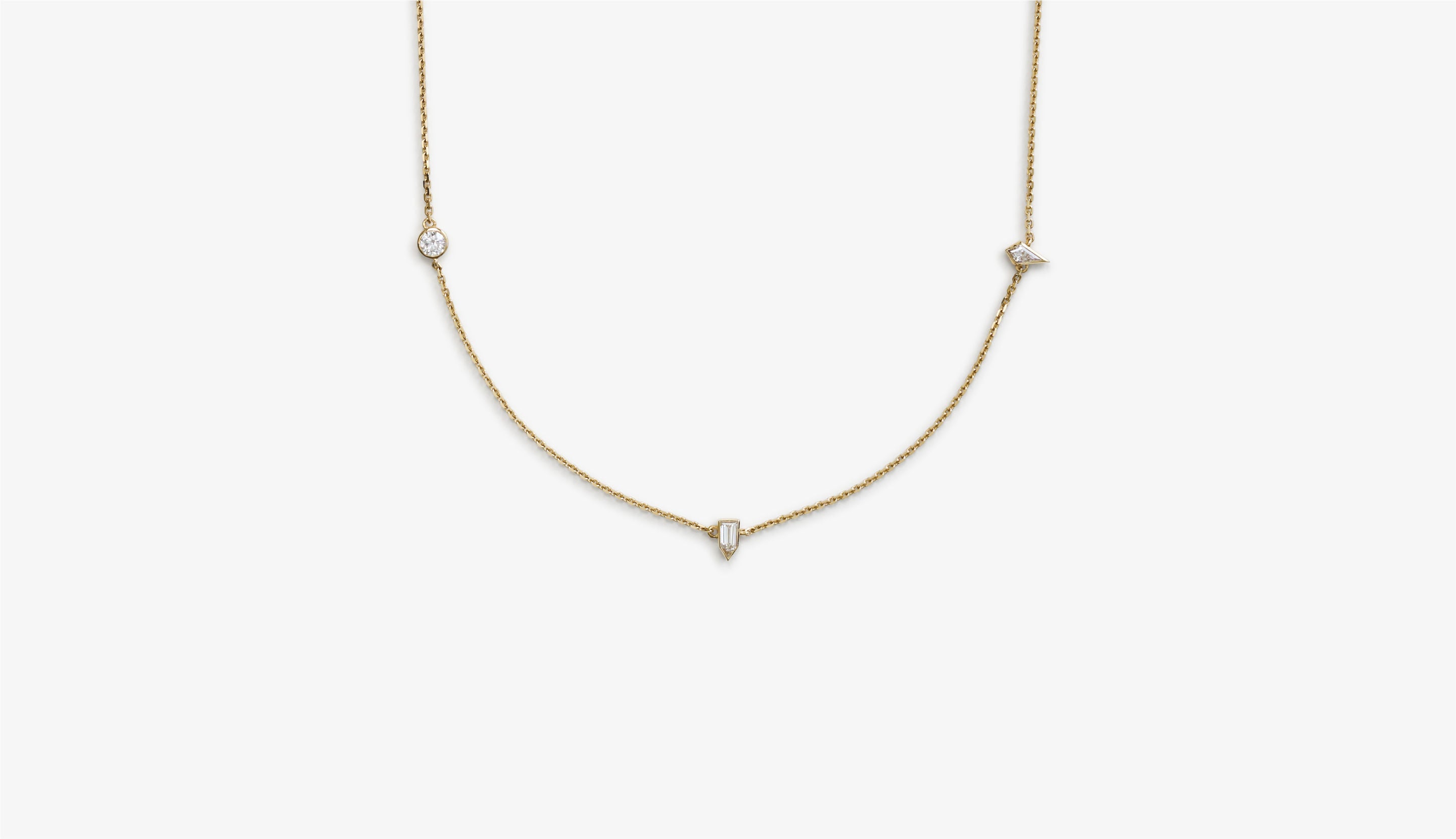 Blonde woman with slicked-back hair wearing a black strapless top and a choker necklace with a large light blue gemstone.