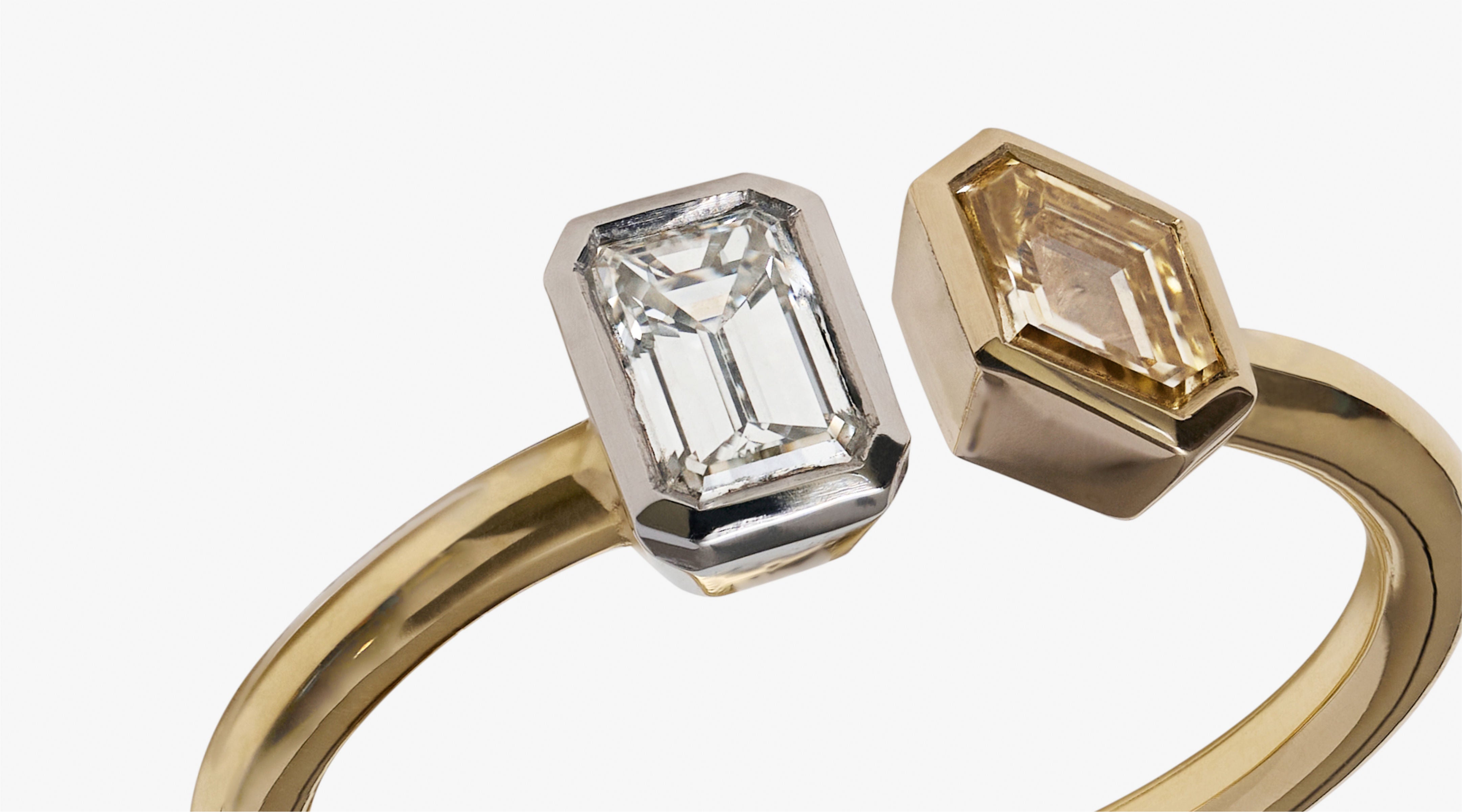 Blonde woman with slicked-back hair wearing a black strapless top and a choker necklace with a large light blue gemstone.