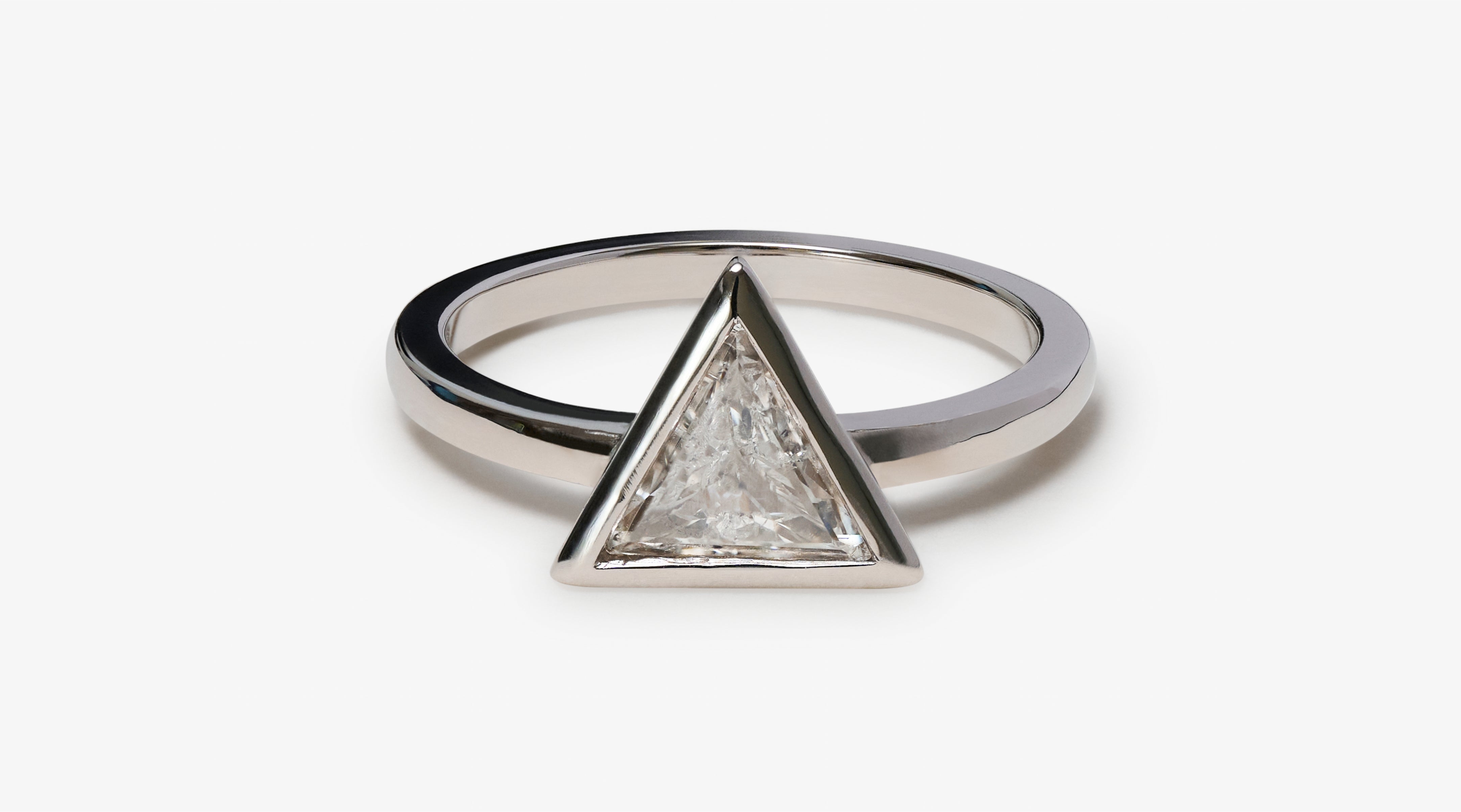 Blonde woman with slicked-back hair wearing a black strapless top and a choker necklace with a large light blue gemstone.