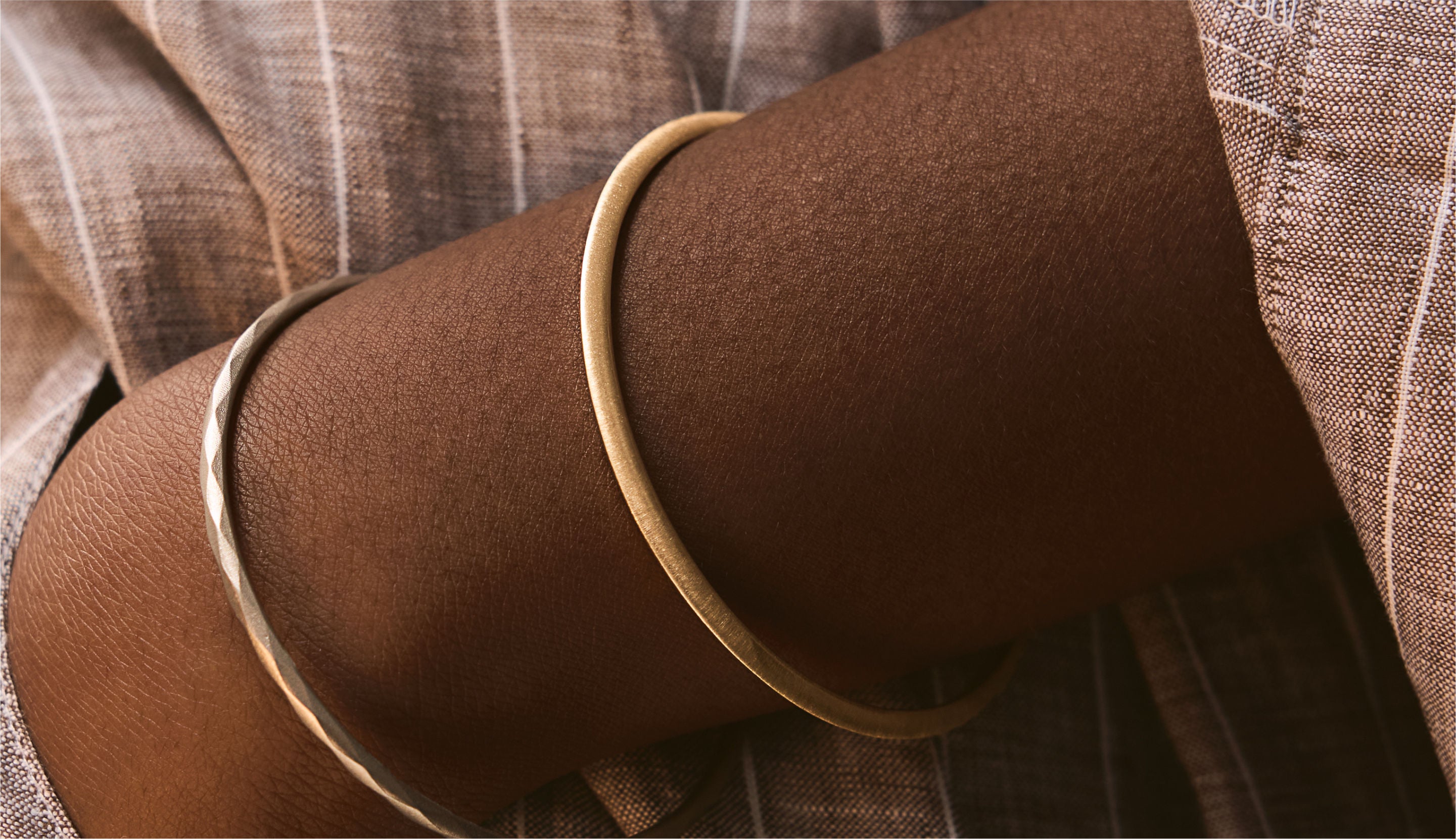 Blonde woman with slicked-back hair wearing a black strapless top and a choker necklace with a large light blue gemstone.
