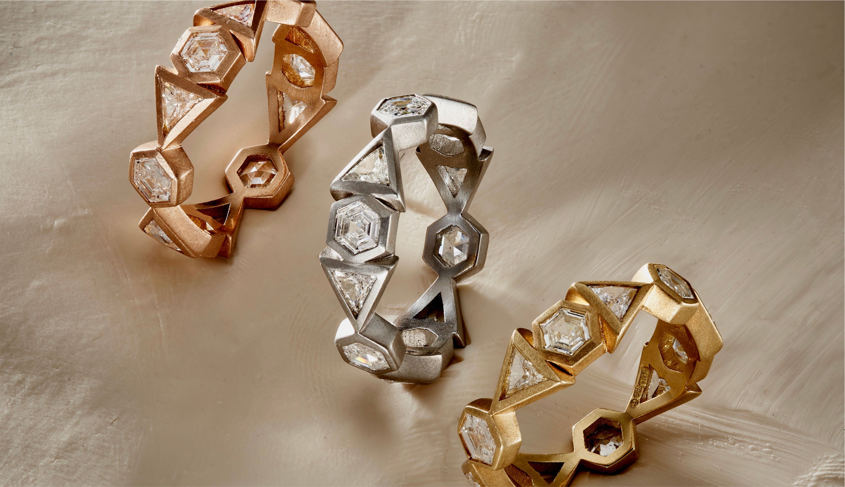 Blonde woman with slicked-back hair wearing a black strapless top and a choker necklace with a large light blue gemstone.