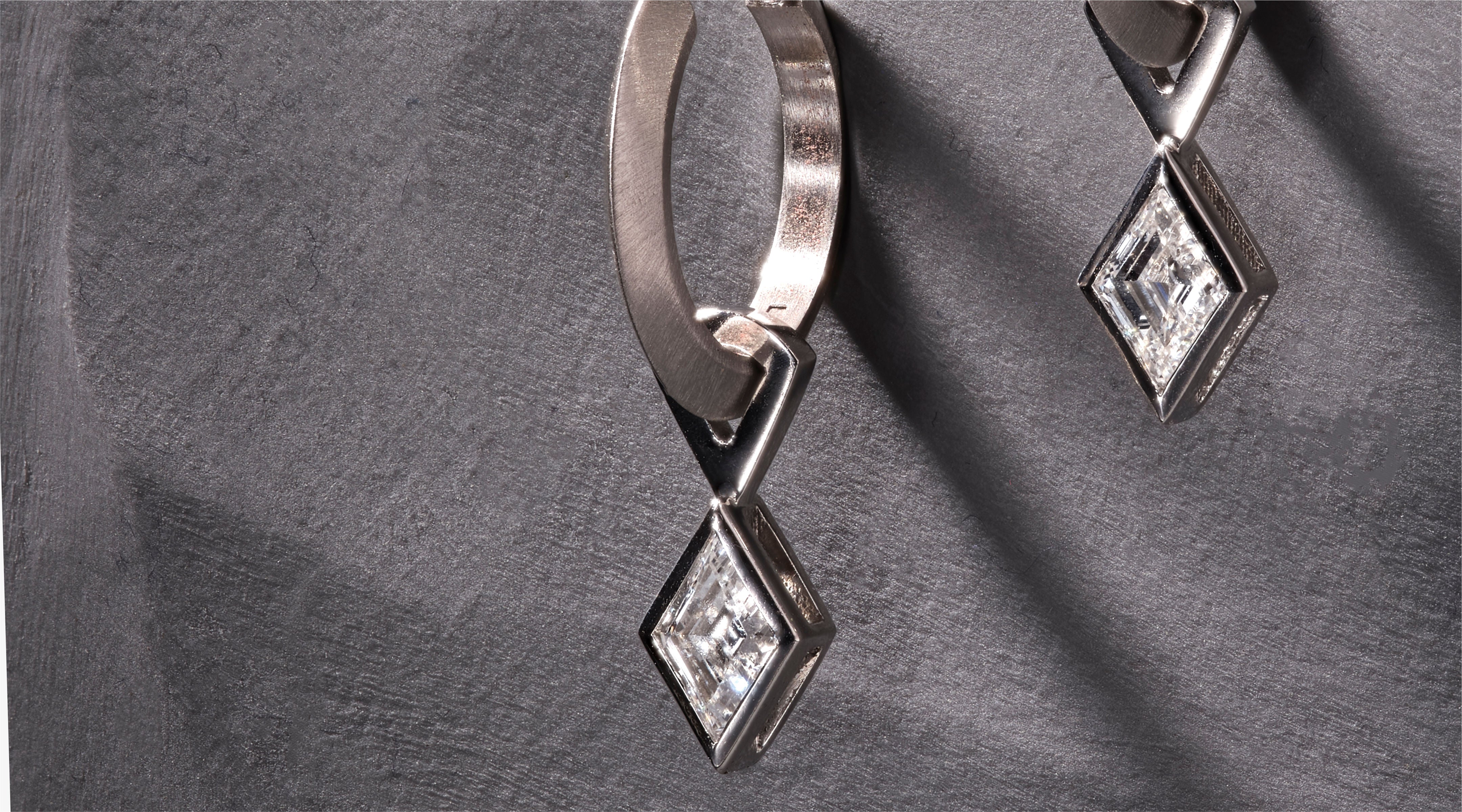 Blonde woman with slicked-back hair wearing a black strapless top and a choker necklace with a large light blue gemstone.