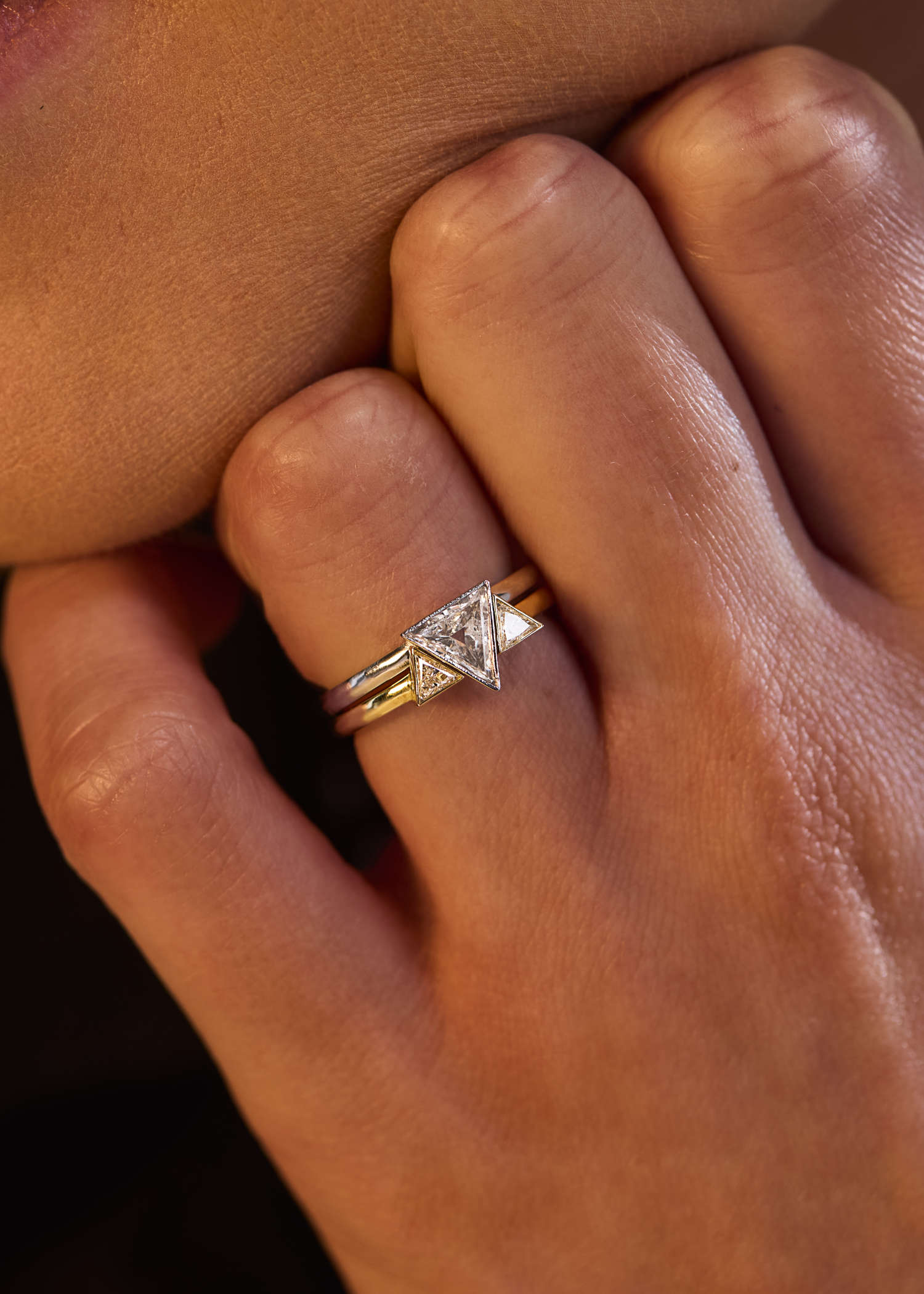 White gold ring with single triangular diamond in minimalist bezel setting.