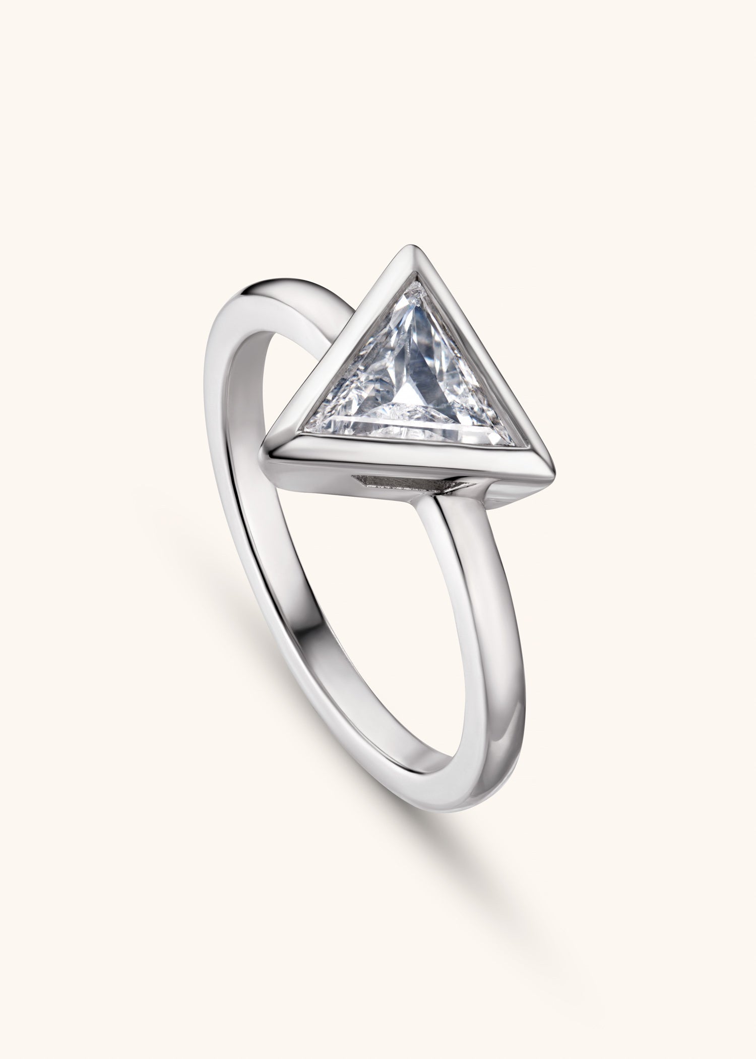 White gold ring with single triangular diamond in minimalist bezel setting.