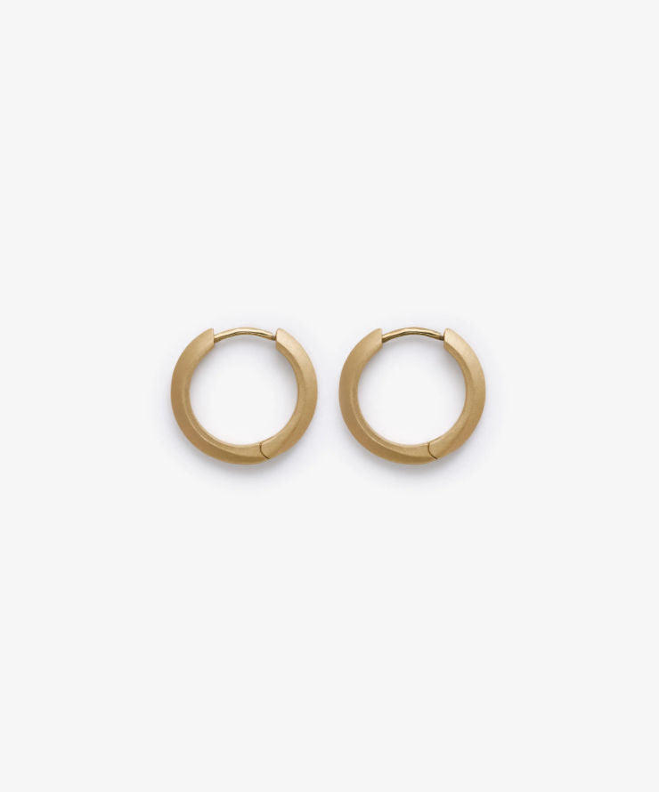 Gold stain hoop earrings on a white background.