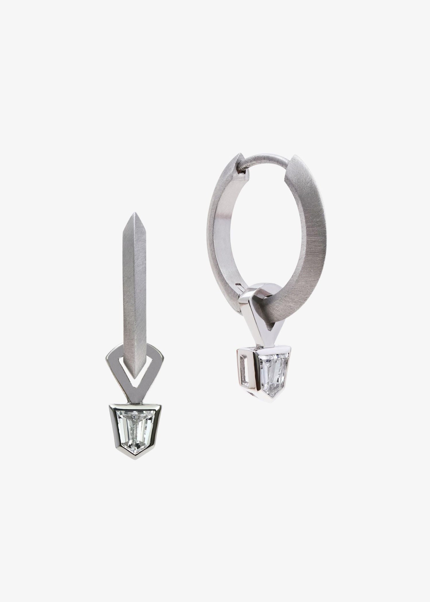 Platinum hoop earrings with geometric bullet-cut diamonds on grey textured background.