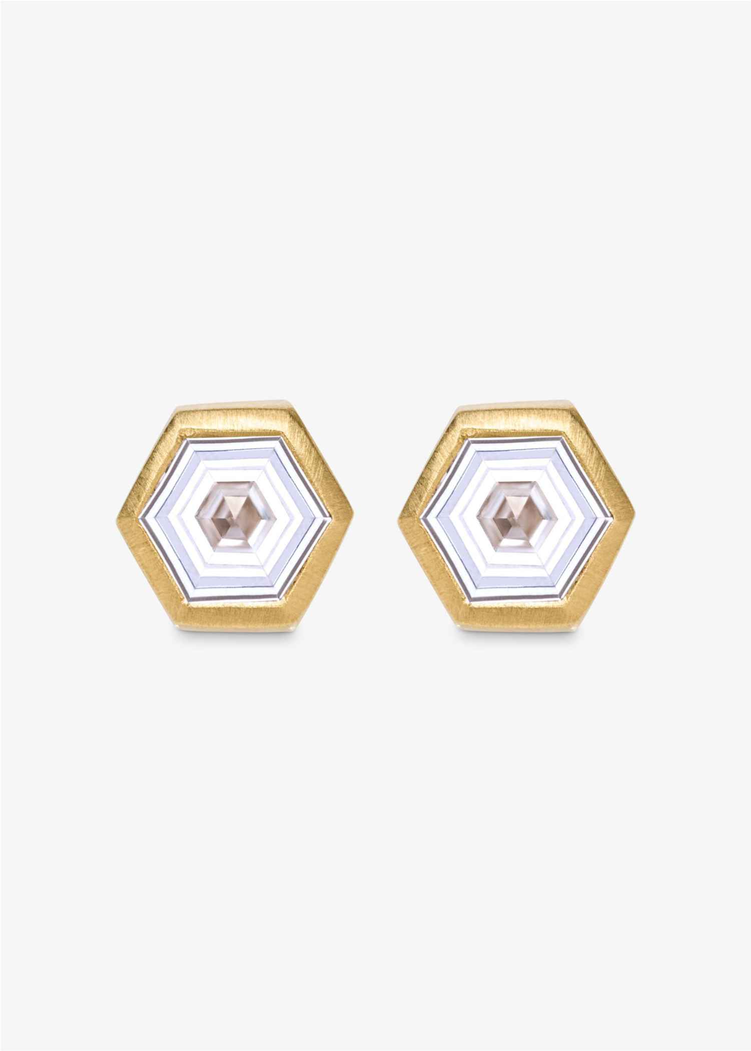 Gold earrings with clear gemstones on a white background.