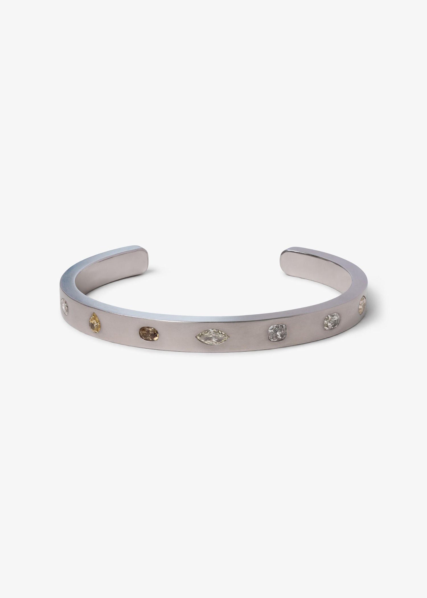 Platinum cuff bracelet with mixed fancy-cut diamonds on matte textured surface.