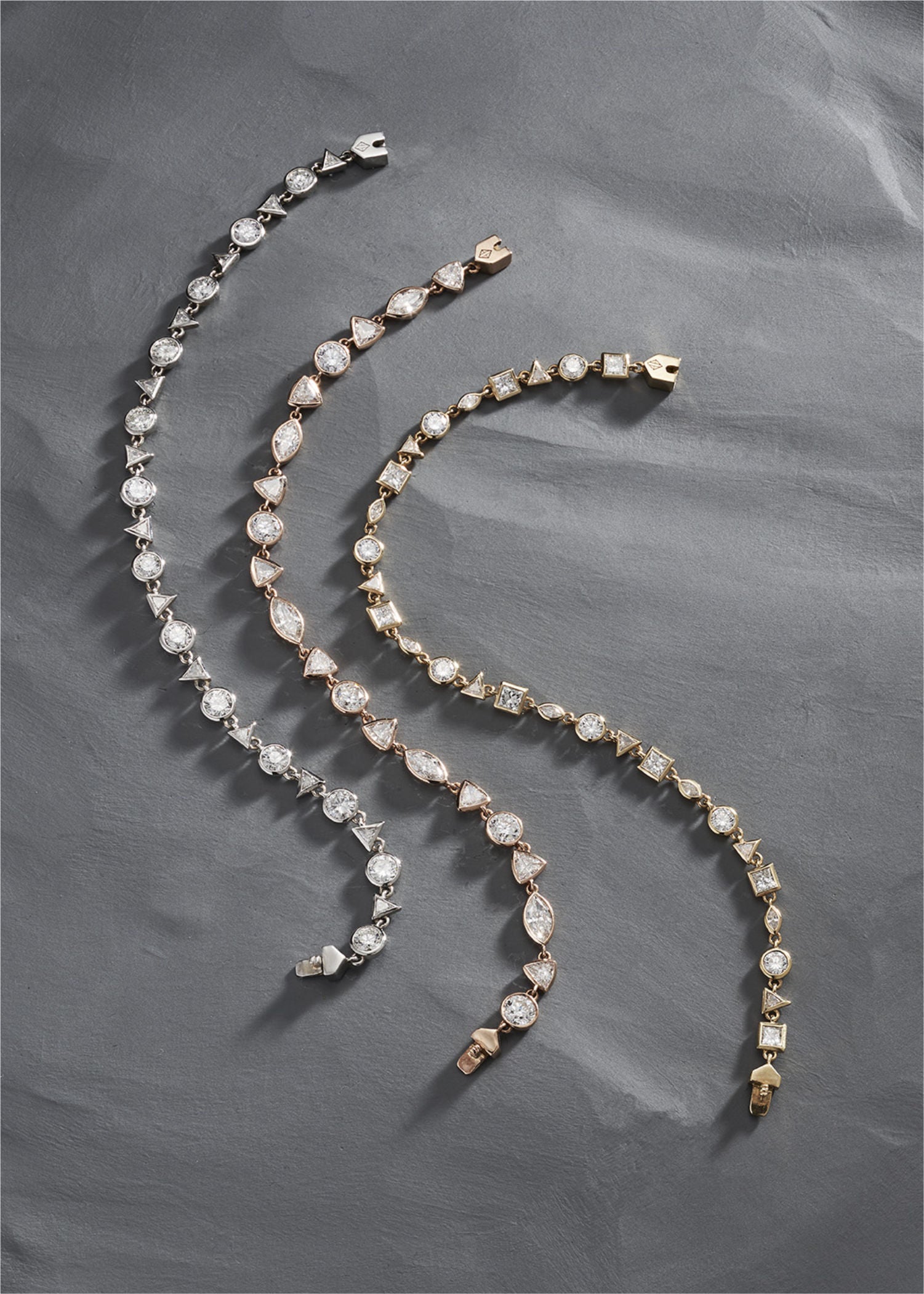 Close-up of rose gold diamond tennis bracelet clasp with round and marquise stones.
