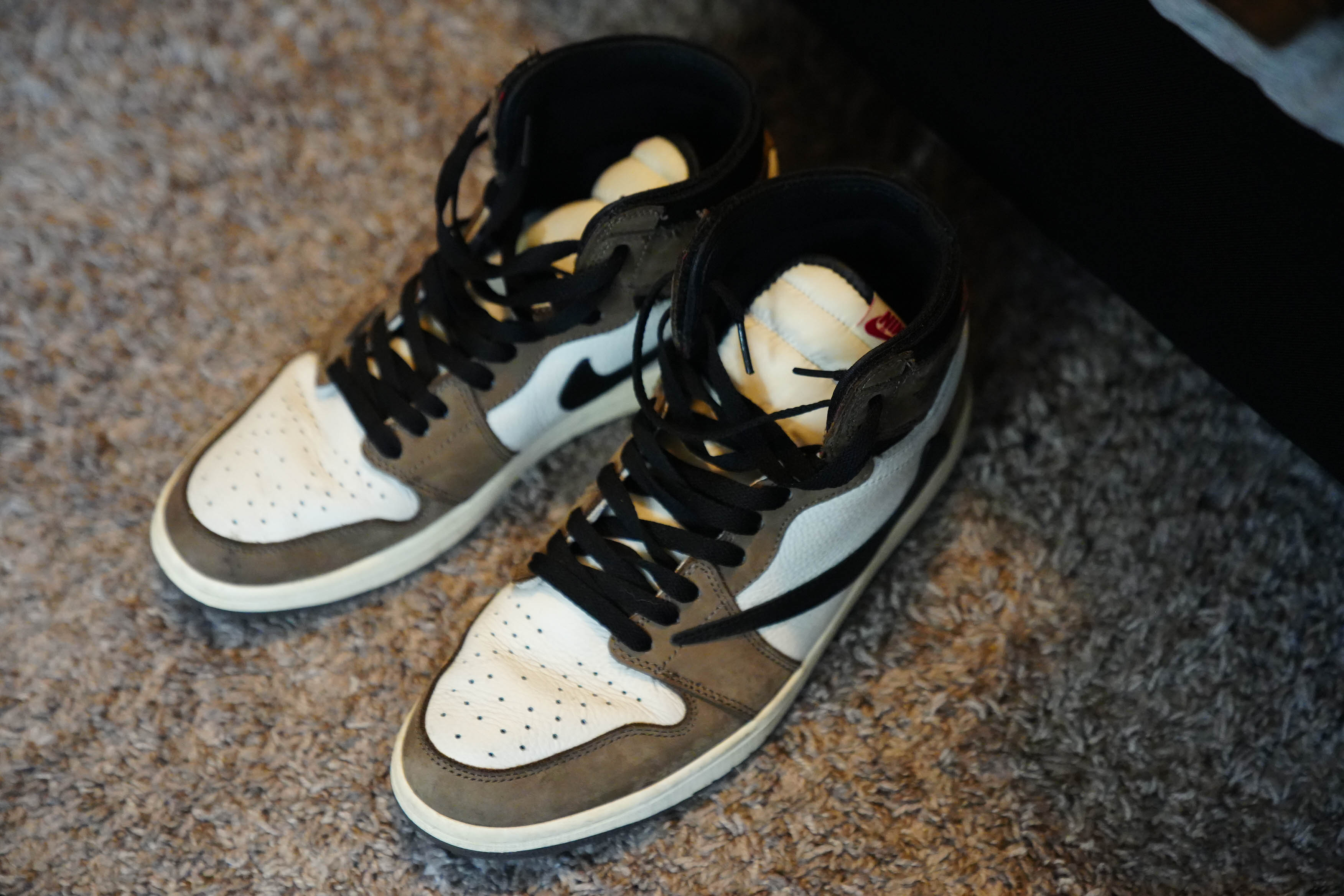 A pair of grey and white Nike sneakers on the carpet.