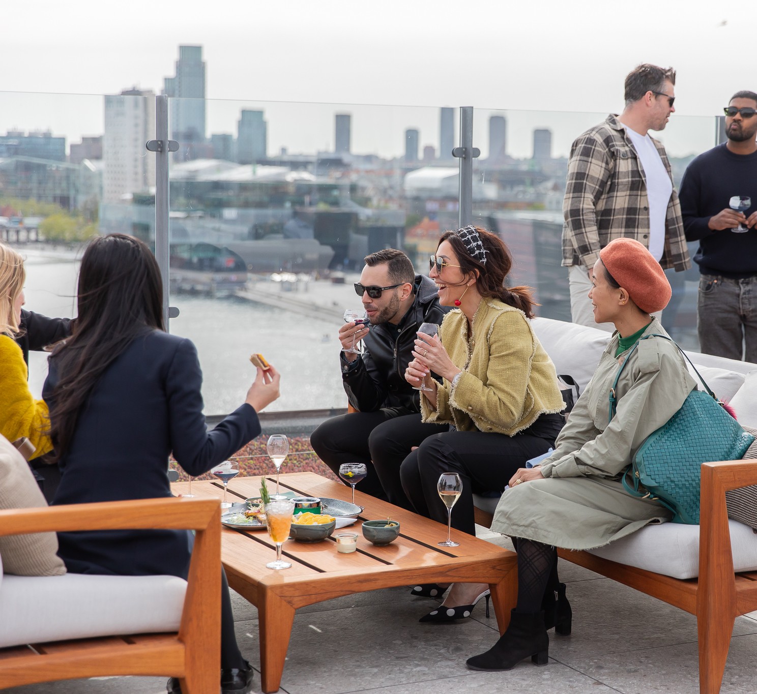 Three oysters served on crushed ice in a round dish, each topped with different garnishes including sauce, herbs, and a slice of orange.