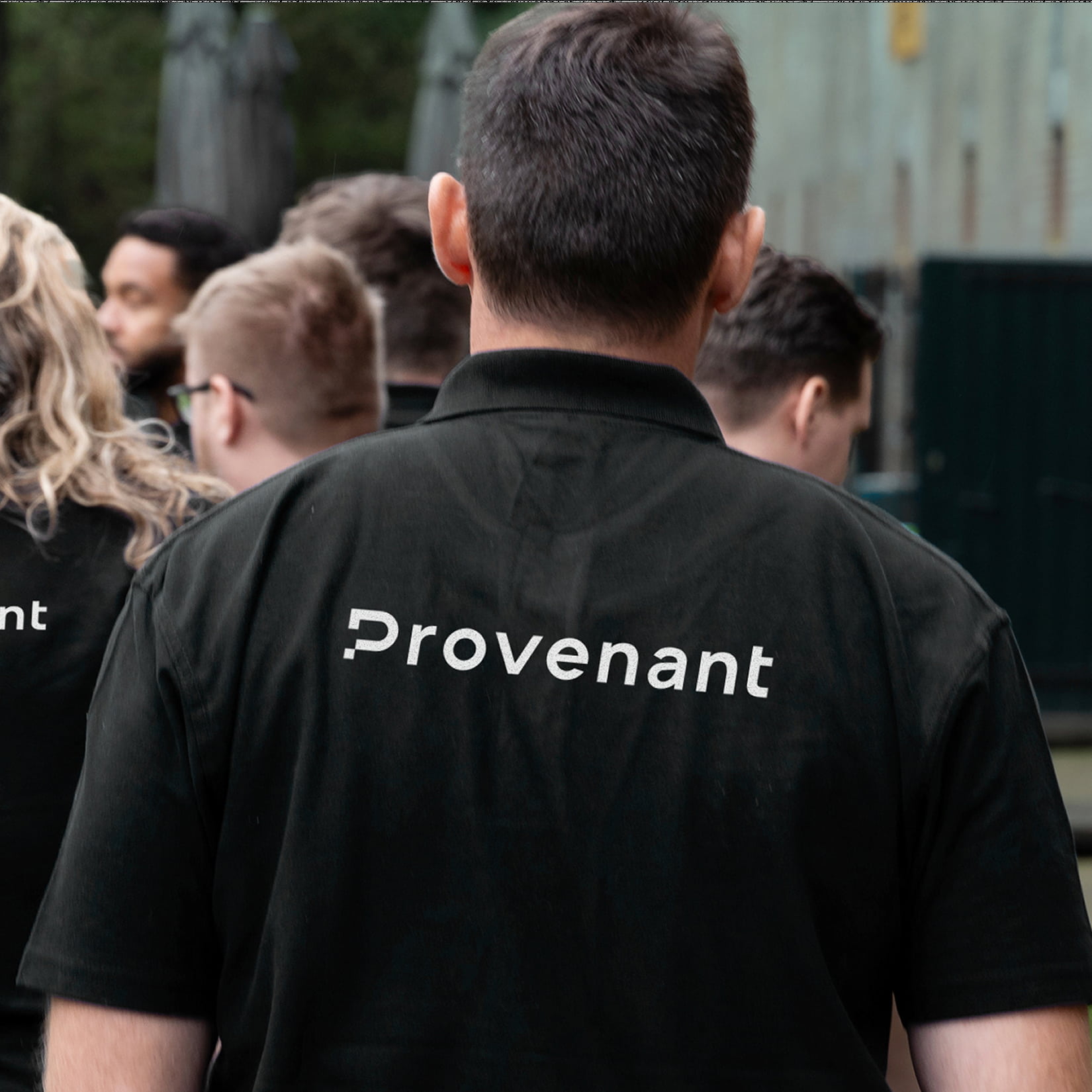 People wearing black shirts with the word 'Provenant' printed on the back, seen from behind.