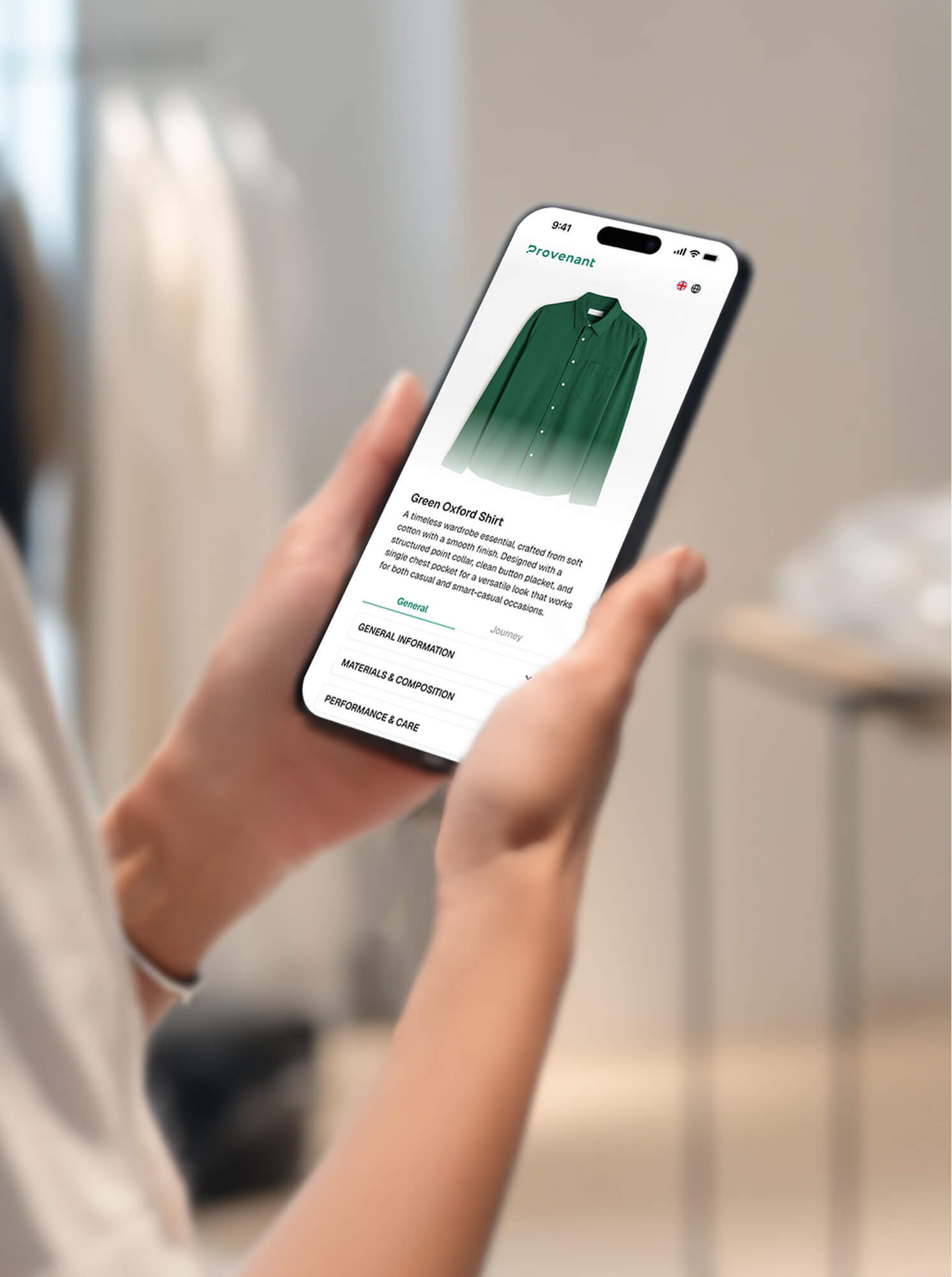 Person holding a smartphone displaying a green Oxford shirt product page with details and care instructions.