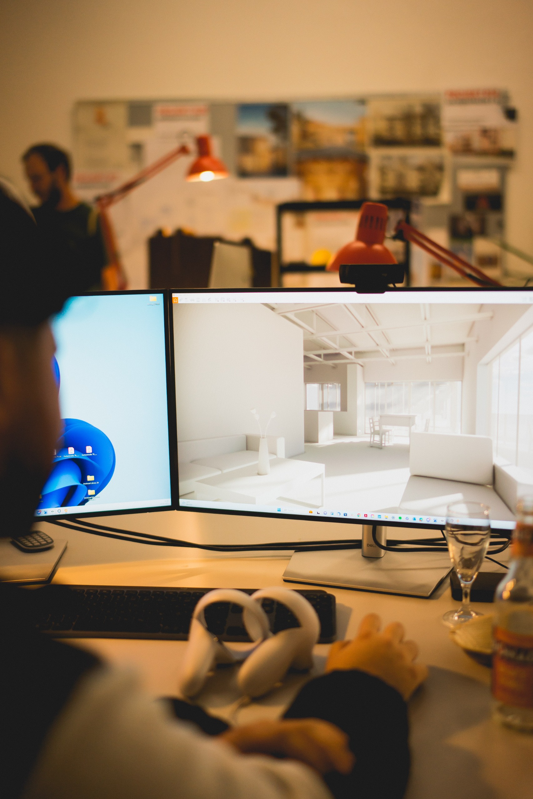 Person sitting outdoors holding a tablet displaying a bicycle video, with another person sitting on a cushioned bench nearby by the water.