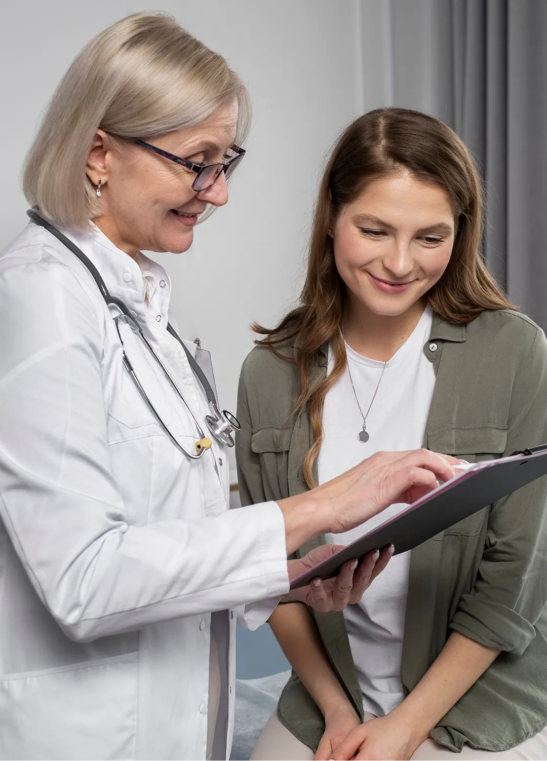 A female doctor and a female patient looking at a clipboard.