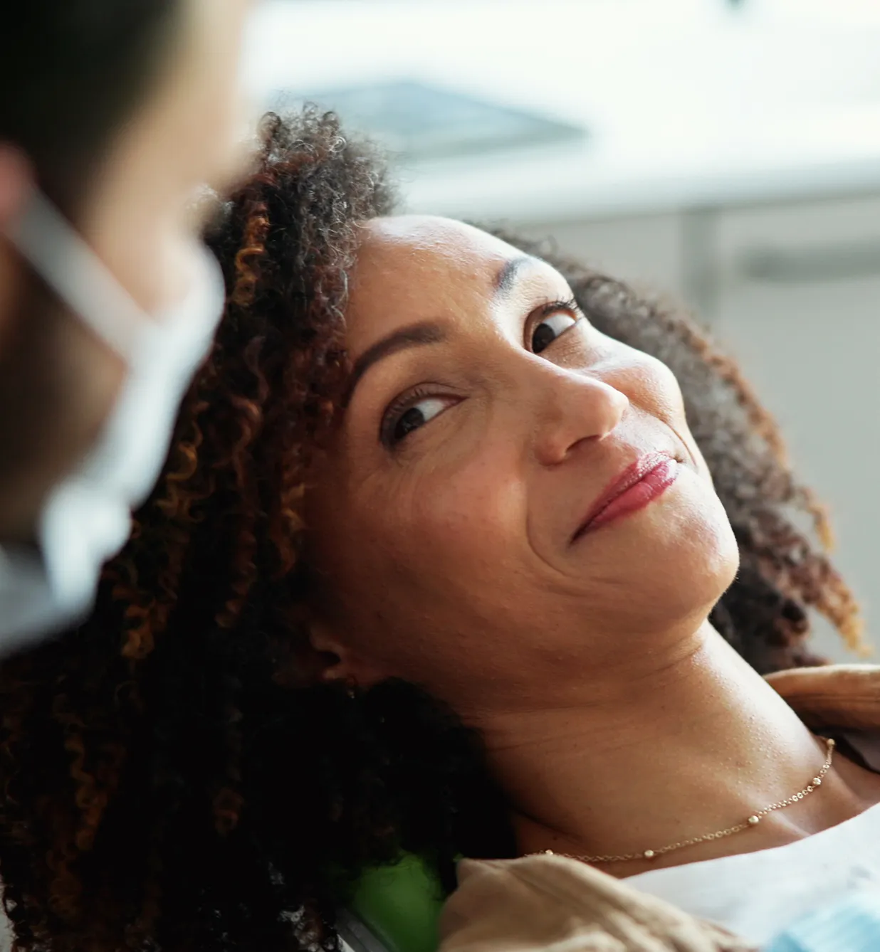 A woman getting her hair done by a man.