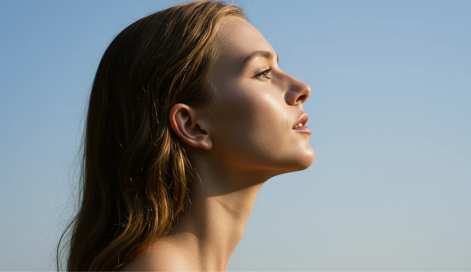 A woman with long hair looking up into the sky.