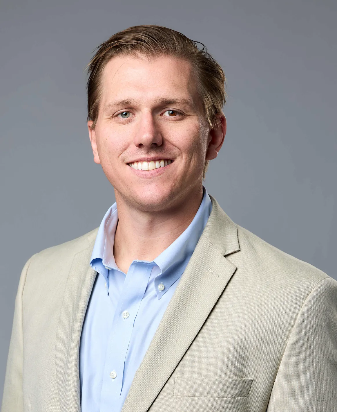 A man in a suit smiling at the camera.