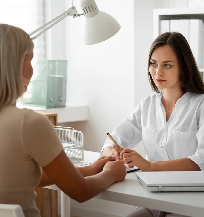 A woman sitting at a desk with a pen in her hand.