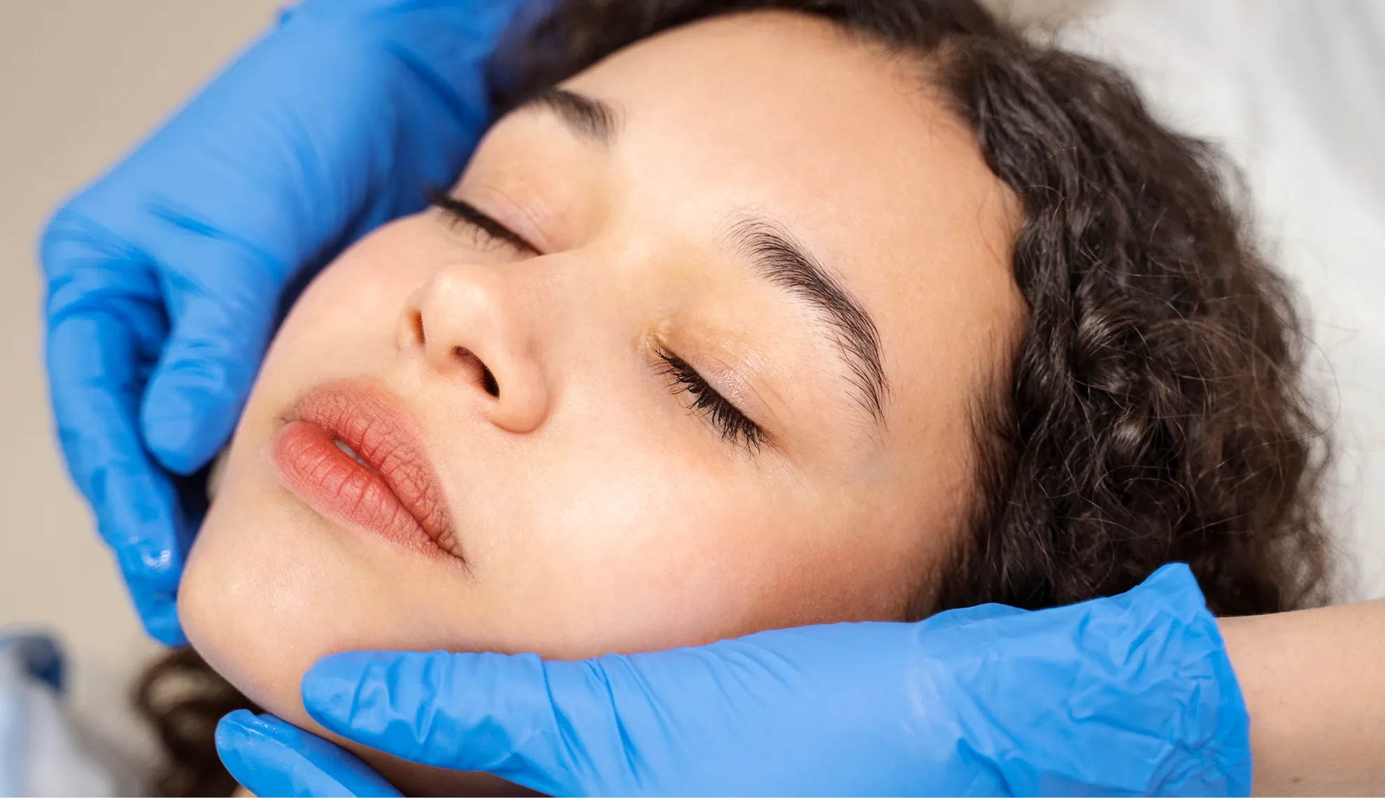 A woman getting a facial massage at a beauty salon.