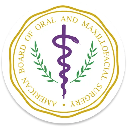 Seal of the American Board of Oral and Maxillofacial Surgery featuring a purple caduceus symbol and green laurel branches inside a gold circular border.