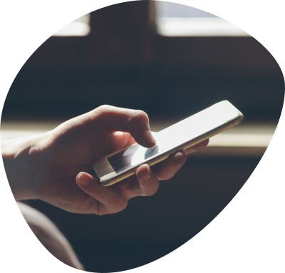 Hand holding and interacting with a smartphone near a window with soft natural light.