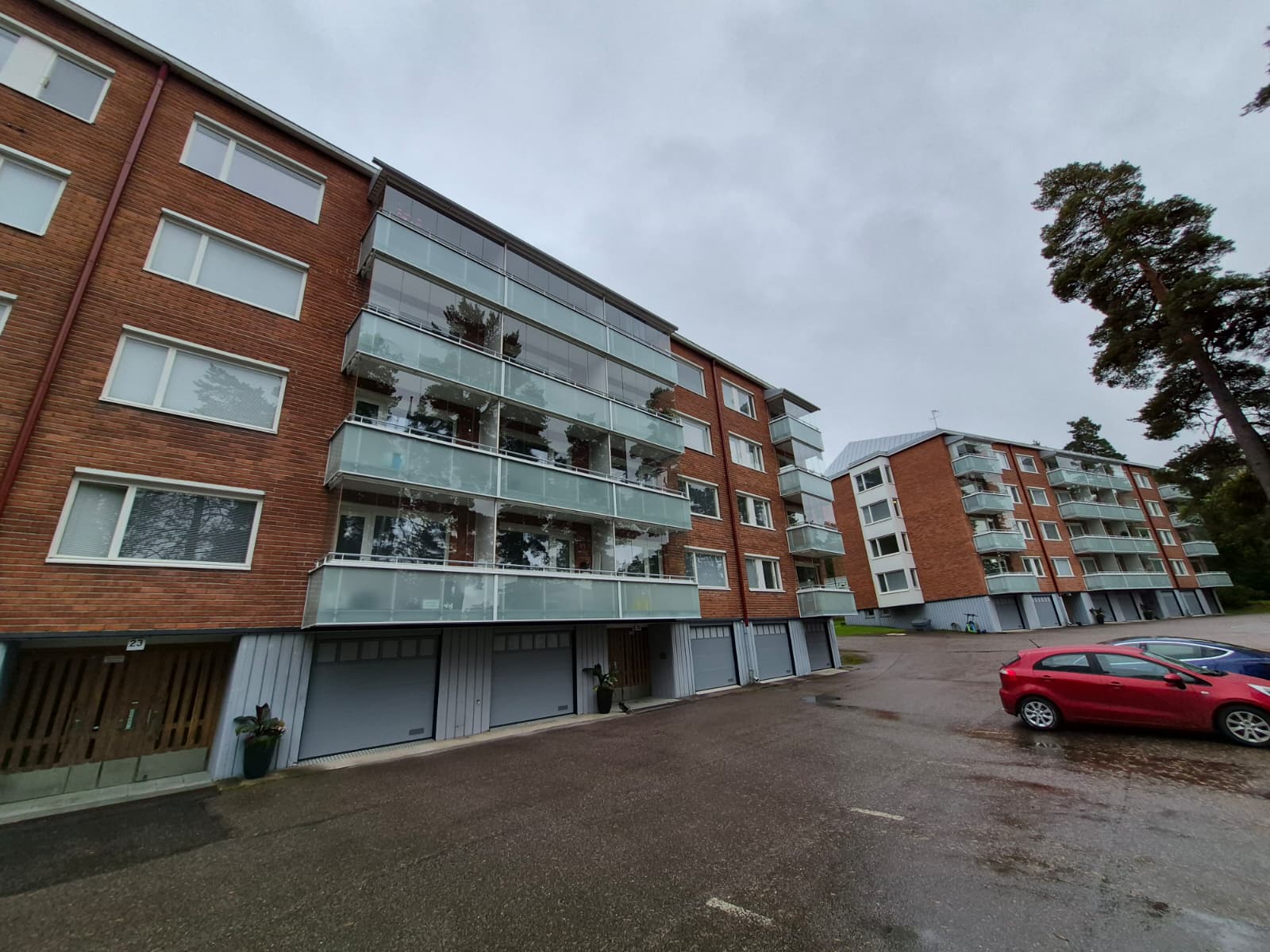 Punatiilinen kerrostalo lasitetuilla parvekkeilla