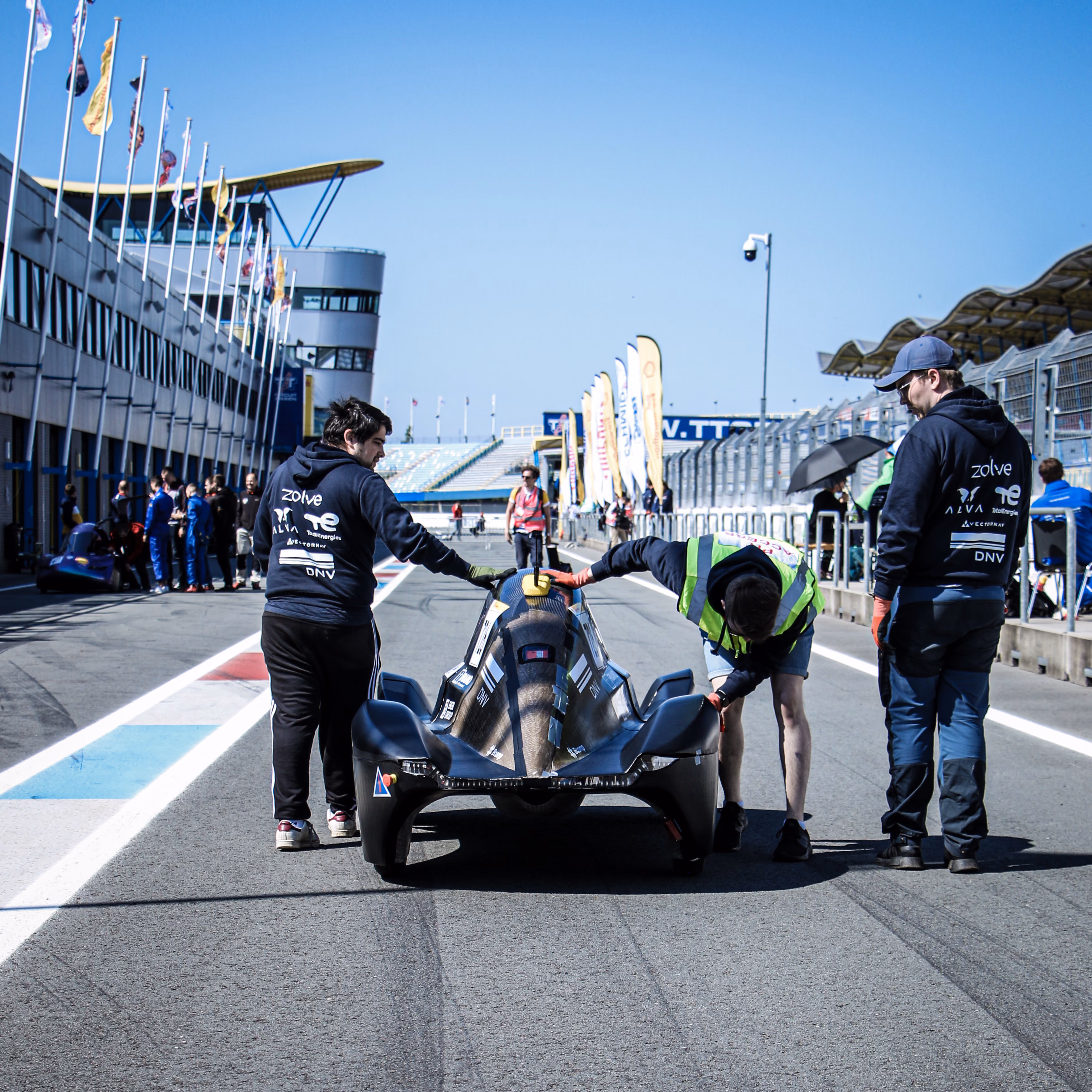 The team pushing the car in the pit lane