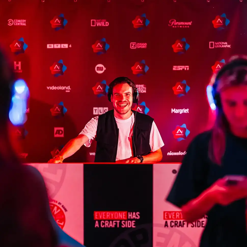 Houten tuintafel met een kleine plantenpot erop, omringd door drie houten klapstoelen op een grasveld.