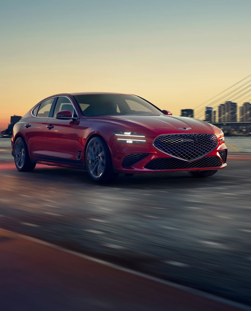 Front 3/4 view of red Genesis G70 driving