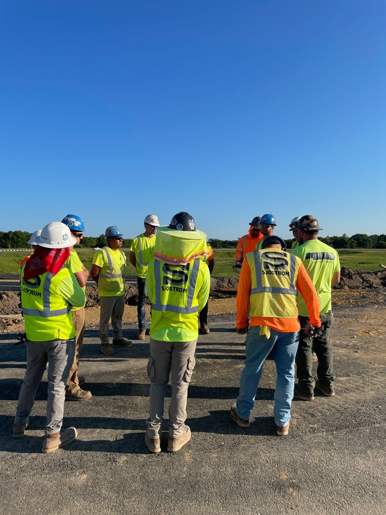 Sjostrom crew huddle on a jobsite