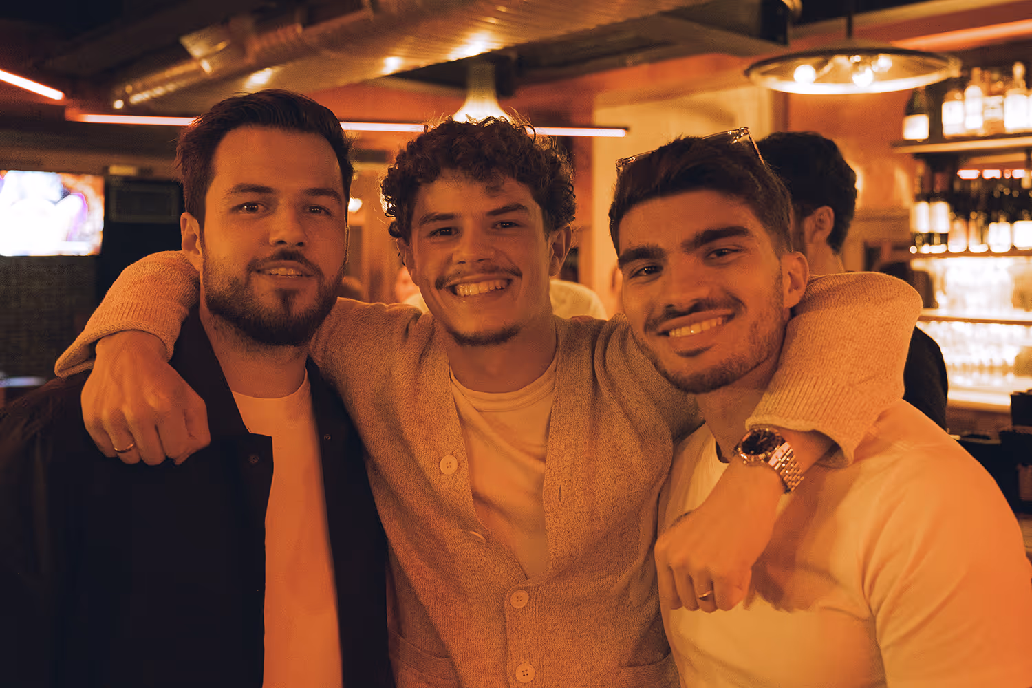 Photo d'un évènement de networking, 3 entrepreneurs regardent la caméra en s'enlaçant