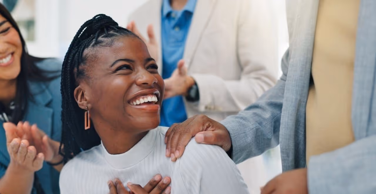 Successful group practice owner being congratulated by her team after achieving business growth