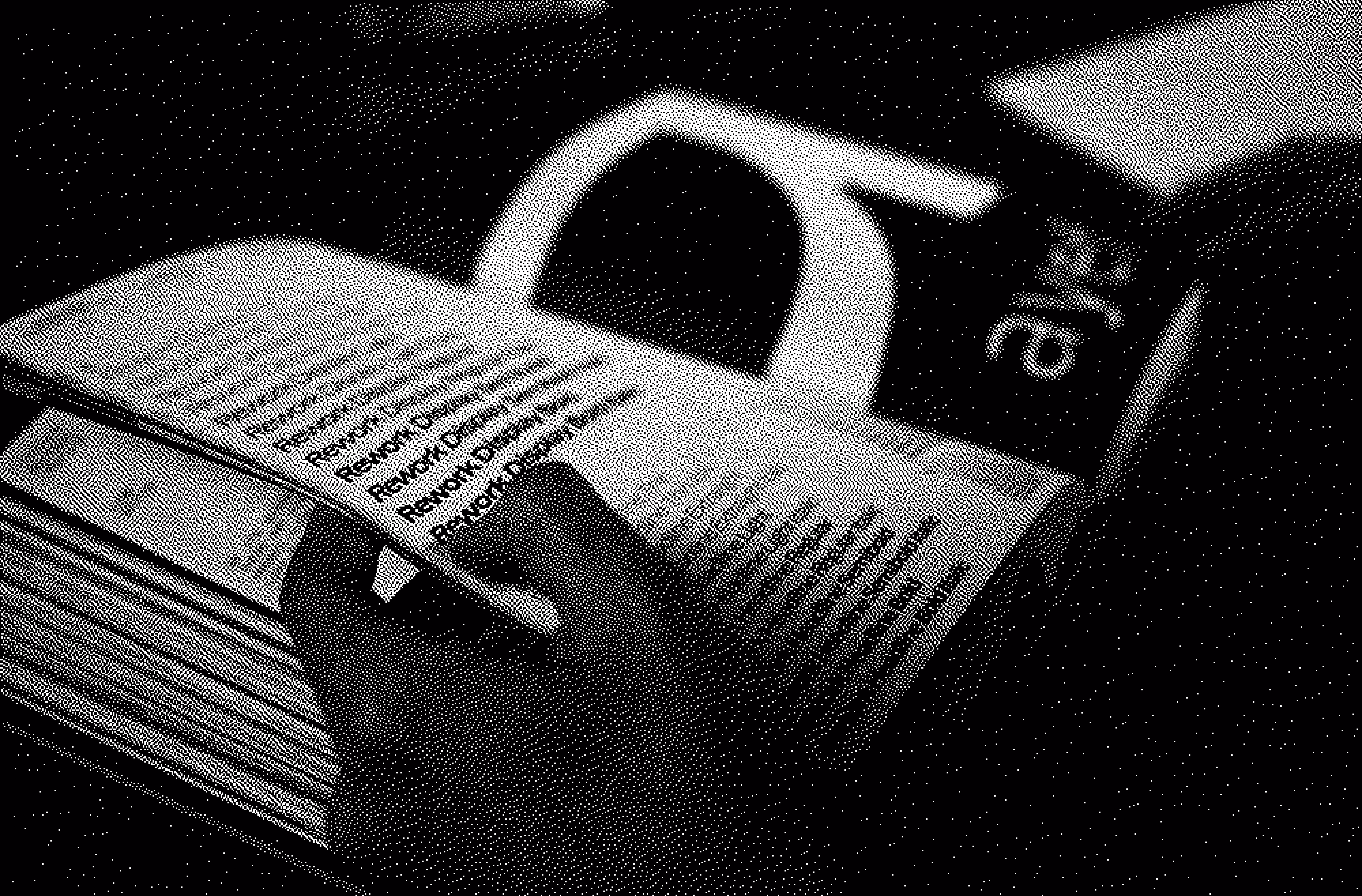 Ethan Suero flipping through a thick book with dense text and a black coffee cup on the table.