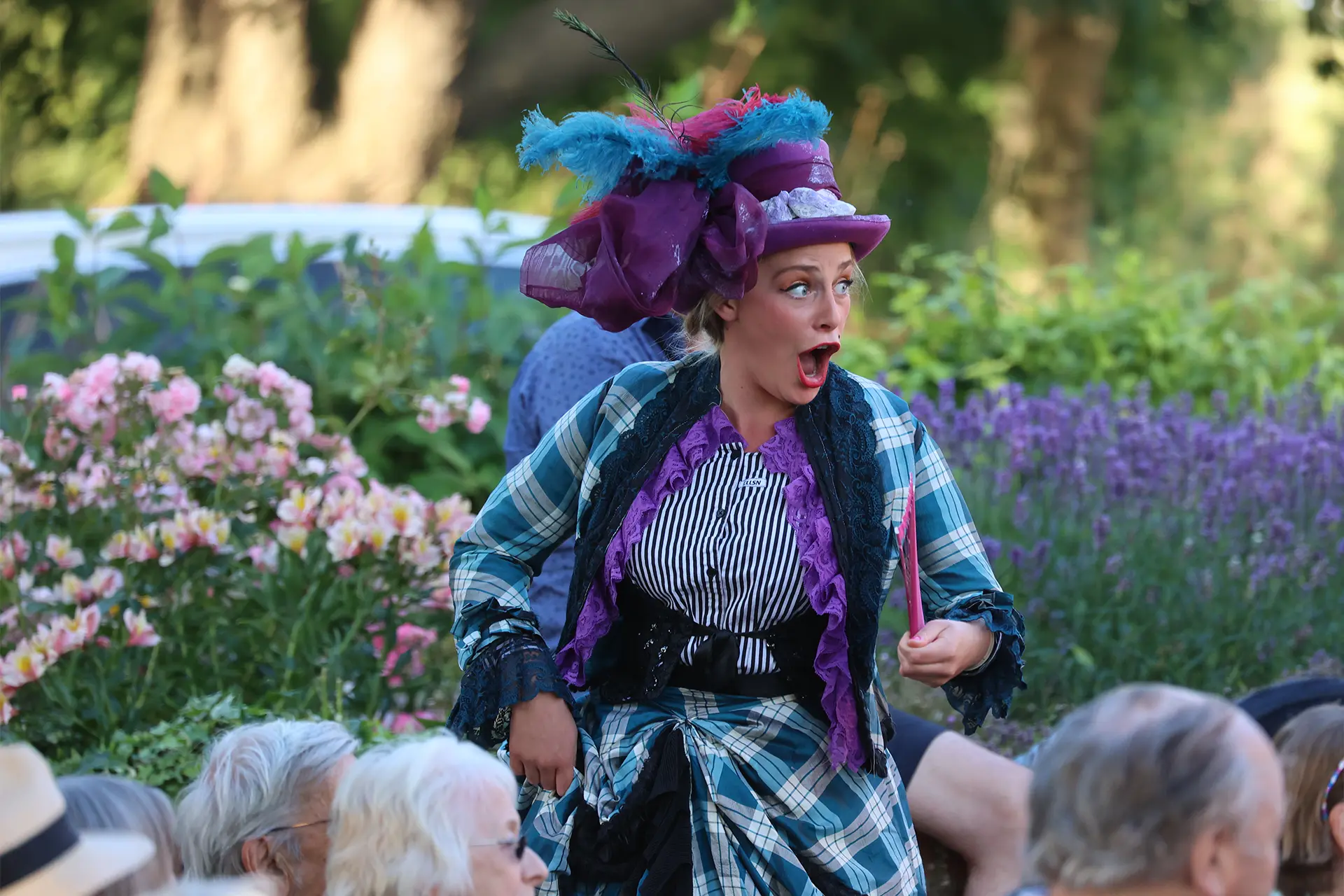 Changeling Theatre performer at the JAM Festival in Victorian purple costume and feathered hat.
