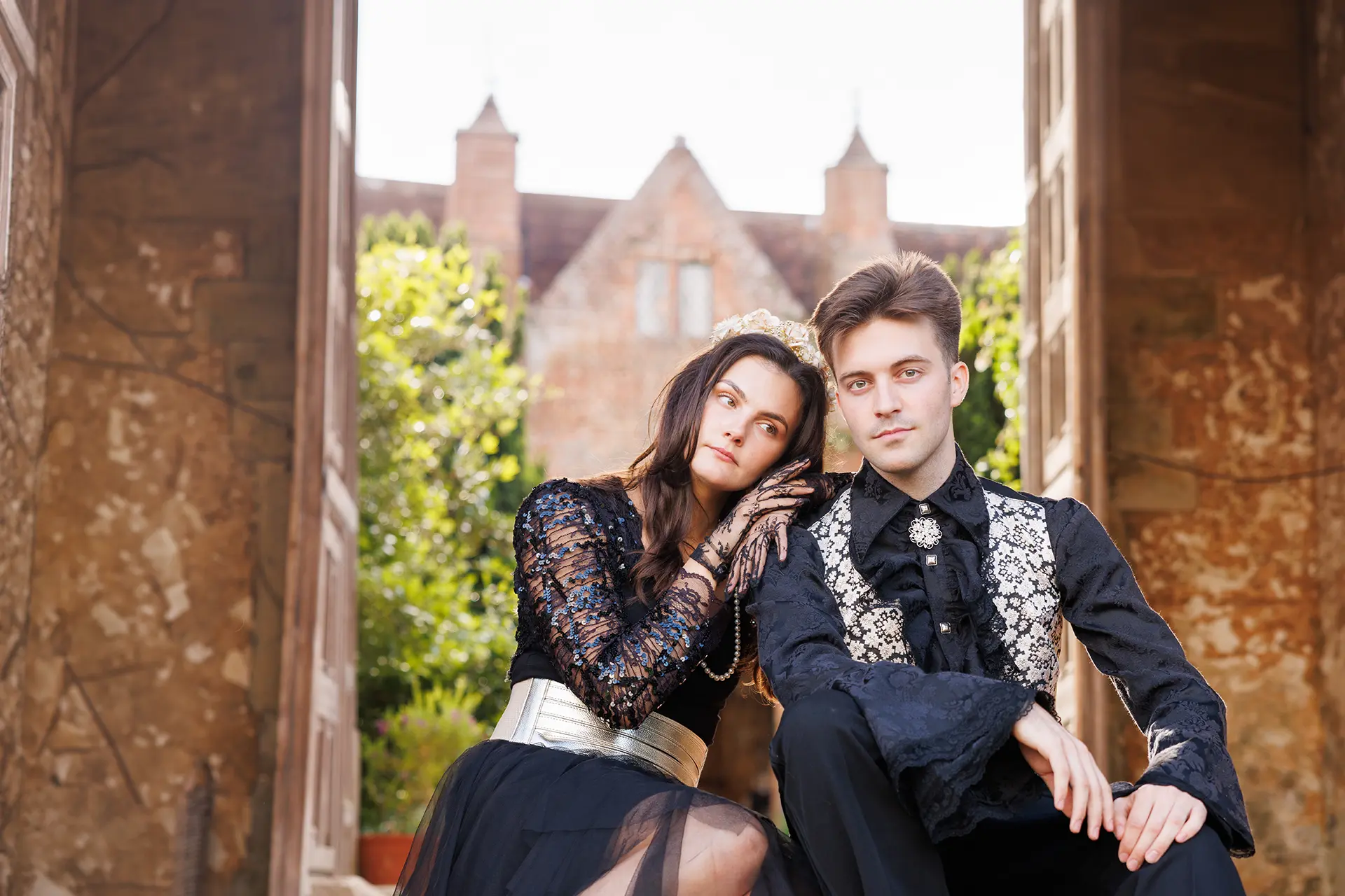 Two actors in elaborate black lace costumes pose on garden steps for Changeling Theatre's Much Ado About Nothing at JAM.