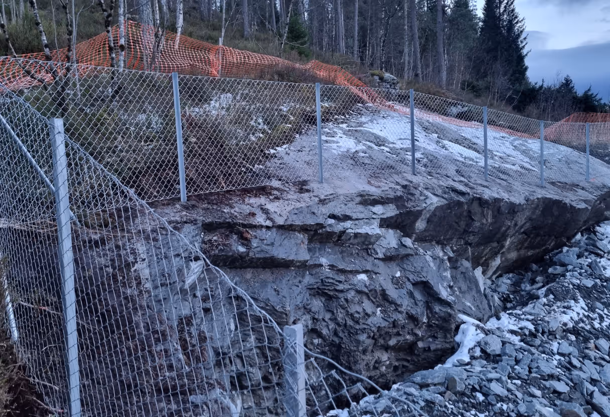 Nettinggjerde langs fjellskråning for å hindre steinras og sikre området.