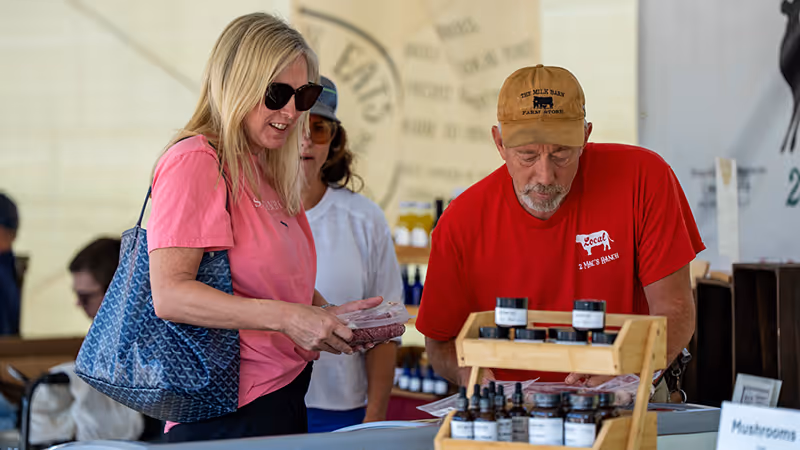 A shopper talks with a local farmer at the Winnsboro Farmers Market, selecting fresh products and homemade goods. Friendly vendors, local ingredients, and small-town hospitality make Winnsboro’s market a favorite weekend destination.