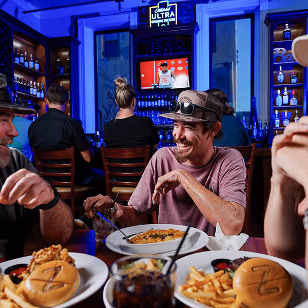 Friends share laughs and great food at a lively Winnsboro, TX bar and grill. With burgers, fries, and cold drinks, it’s the perfect spot to relax, watch the game, and enjoy small-town hospitality in East Texas.