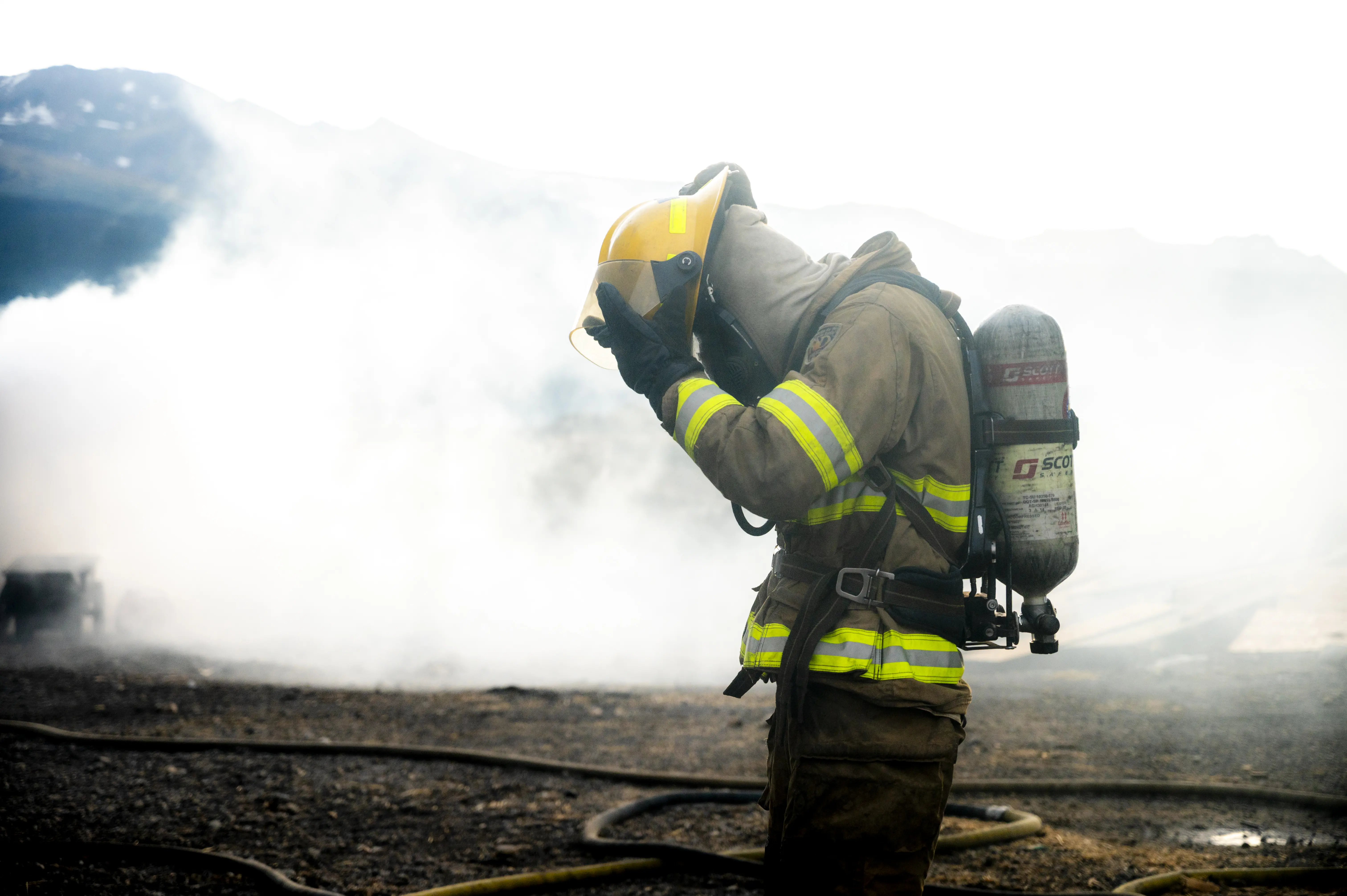 firefighter student taking off helmet after fire practice