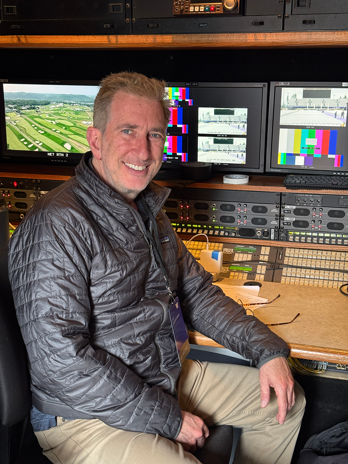 Larry Struber seated at a desk smiling passionately in front of video editing equipment