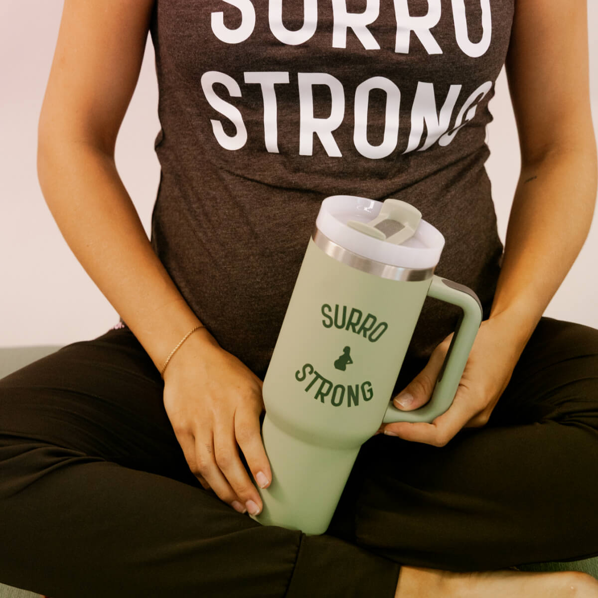 Woman wearing a gray and white camouflage baseball cap with the words 'SORRO STRONG' embroidered on it.